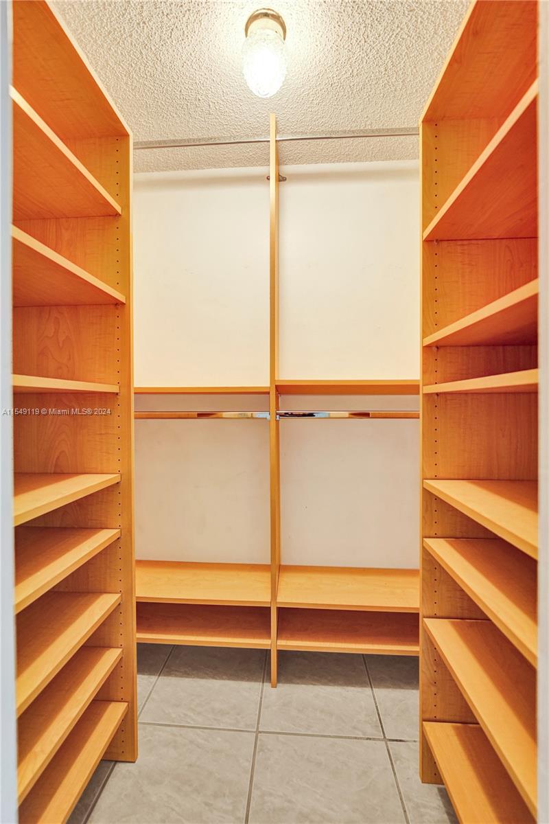 Walk in closet in 2nd bedroom with built-in shelving