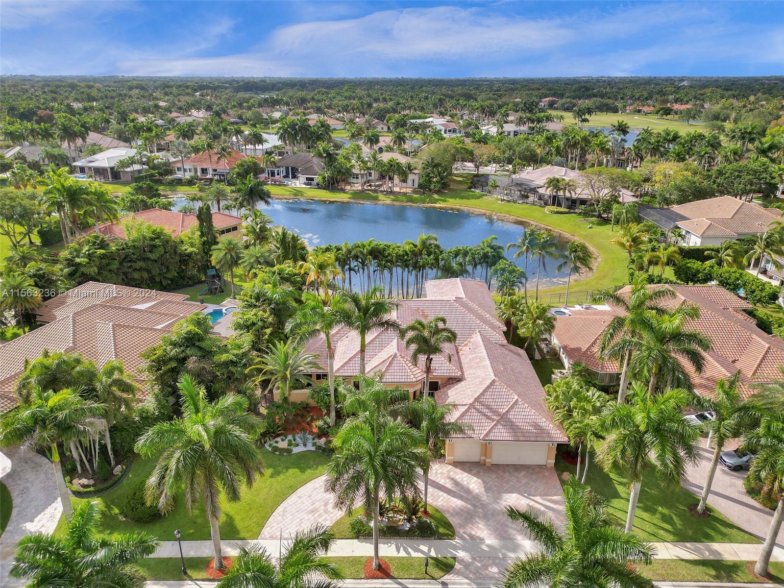 Custom estate in prestigious neighborhood of Poinciana at Weston Hills CC. Situated on 16,345 sqft lot with circular driveway surrounded by royal palm trees and lush landscaping for ultimate privacy. Step inside to large windows that captivate water and pool views. Open layout with high ceilings, crown moldings, decorator touches, and natural light. Double-split floor plan office with custom library. Oversized primary bedroom with sitting area with dual walk-in closets, and dual marble bathrooms with jacuzzi and pool access. Gourmet kitchen has center island with granite, new stainless refrigerator, and wet bar. Backyard, ideal for entertaining, includes a resort-style pool, paver deck, and covered patio. Plus, living here means access to Weston's top-rated schools and lifestyle.