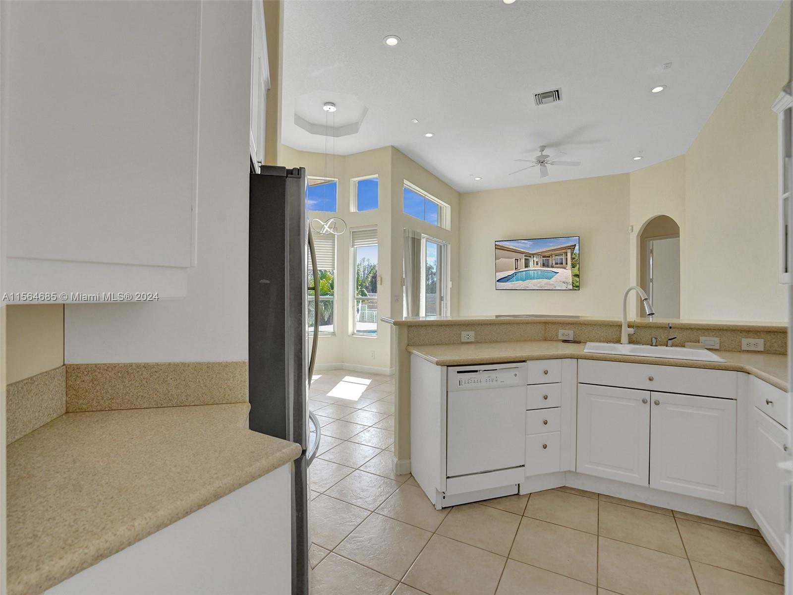 Kitchen faces west towards large windows and sliders to the pool