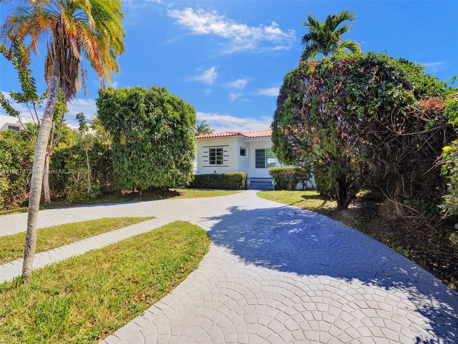 A private gate at the front leads you to a circular driveway, offering convenience and privacy from the bustling streets of Miami Beach.