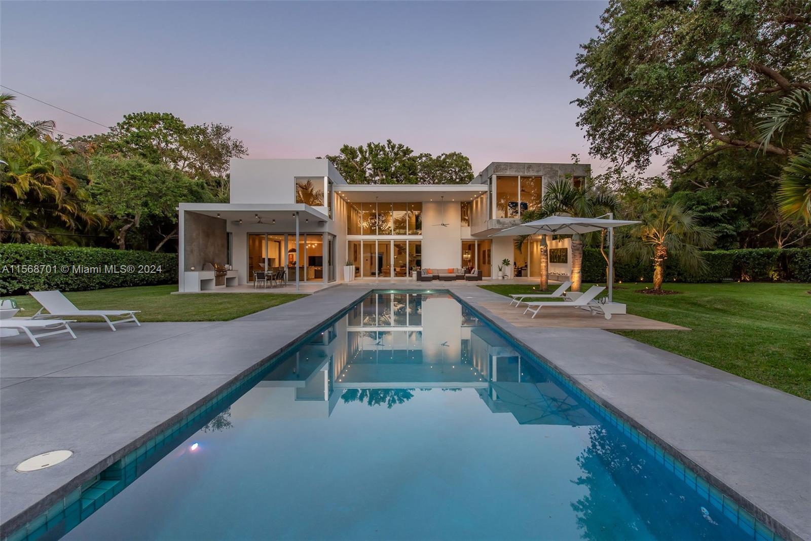 A contemporary masterpiece in the sought-after neighborhood of Pinecrest. This Bauhaus style property features glass walls that bring in natural light and offer breathtaking views of the pool, guest house, and beautiful landscape. This gem also has 6 bedrooms, 6 bathrooms, a full-sized guest house, oversized garage and a fully equipped outdoor kitchen. The living areas and German Leicht-designed kitchen are ideal for hosting. Surrounded by large trees and meticulously landscaped gardens, this private oasis offers a picturesque environment. The large covered terrace, expansive deck, and pool create a seamless indoor/outdoor experience for the perfect retreat. Area: Liv 5,457, Adj 6,327, Total 7,601.