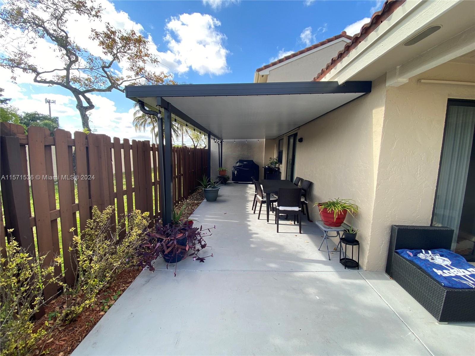 View towards the kitchen of the outdoor space under shade - WINDOWS AND DOORS ARE IMPACT