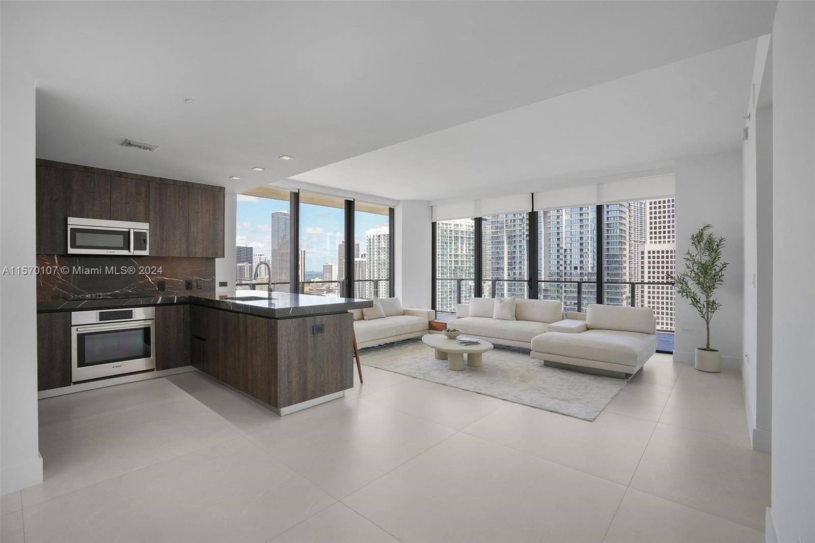 This fully remodeled 2-bed, 2.5-bath sanctuary boasts breathtaking sunrise views of Biscayne Bay and the City. Stride into elegance with 48x48 Gubi Porcelain tile flooring throughout. The modern kitchen features Italian cabinetry, honed marble countertops, premium Bosch appliances, and a wine cooler. Indulge in the primary bathroom's freestanding bathtub and stunning 120x120 Eco Ceramics wall tiles. 

Enjoy seamless indoor-outdoor living with a wrap-around balcony and floor-to-ceiling windows, complemented by electronic blinds in the bedrooms. Steps away from Brickell City Centre, The Rise Condo offers 5-star amenities, including a state-of-the-art fitness center, 24-hour concierge, valet services, heated pool, business center, child's playroom, Hamman spa, and steam room.