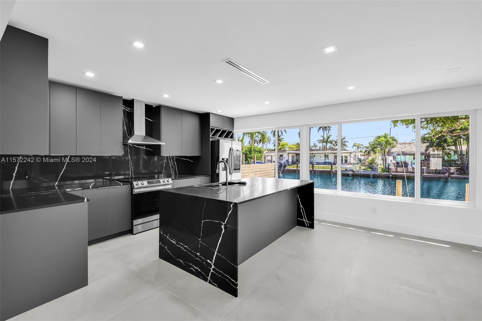 BRAND NEW ROOF, BRAND NEW AC, ALL IMPACT WINDOWS. This stunning property has undergone a meticulous transformation revealing a masterpiece of modern living with 70 ft of water frontage & ocean access. Every inch of this residence has been thoughtfully reimagined. The heart of this home is its modern kitchen & open layout with tile floors, plenty of natural light creating a bright & welcoming ambiance. Step outside to the expansive outdoor oasis, where the enchanting melody of the water complements the generously sized patio invites al fresco dining while the private dock offers a gateway to endless nautical adventures. Pool installation is negotiable.