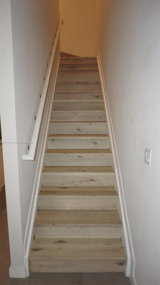 staircase to upper level with wooden steps