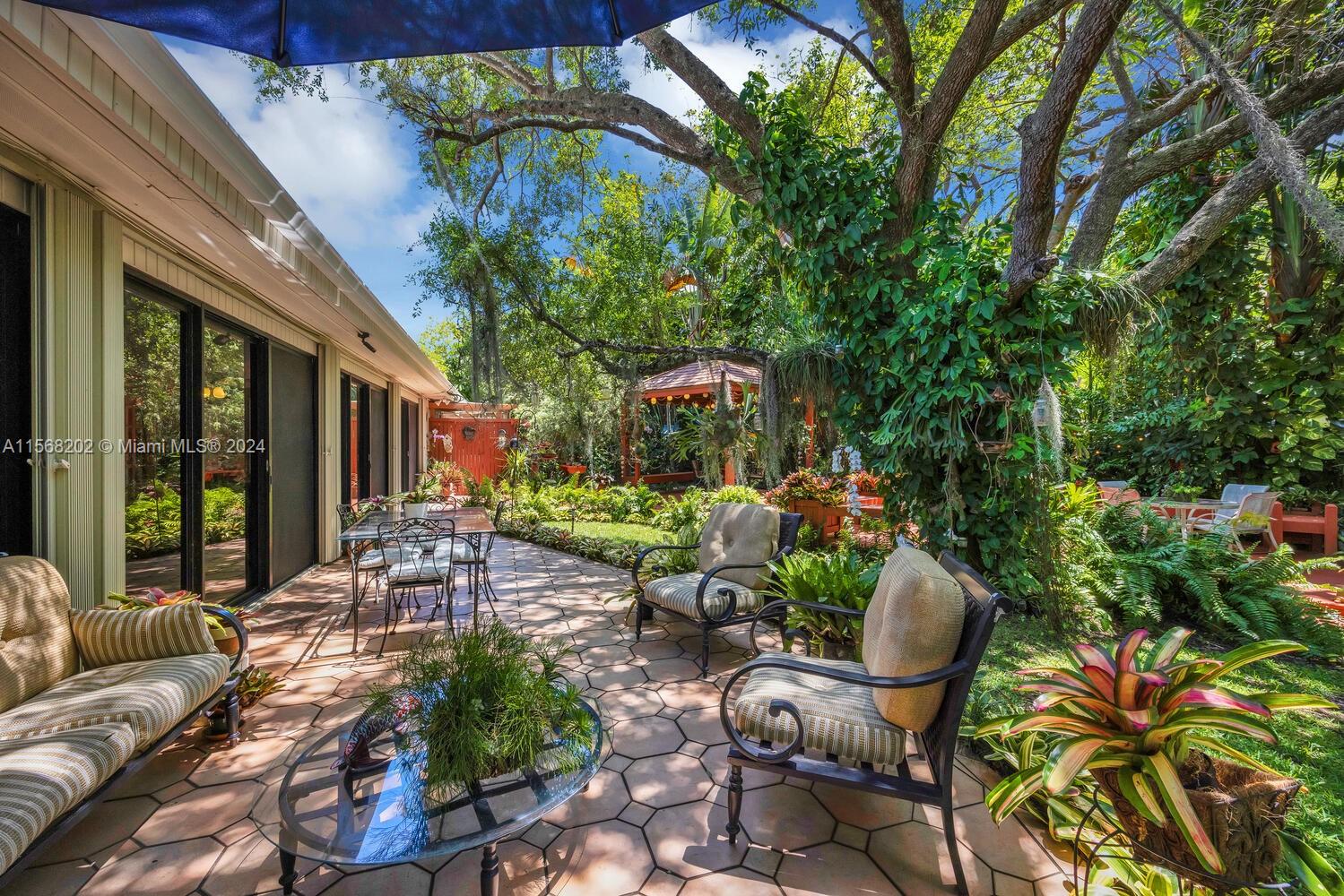 Reminiscent of Fairchild Tropical Garden, this very private oasis will delight & enchant you w/ its vibrant tapestry of colors, textures & beauty. Nestled on almost a half-acre in the prestigious gated community of King’s Bay, this home has been lovingly cared for by the same owner for many decades. The primary suite enjoys its own dedicated wing w/ an attached office/study apart from the secondary bedrms. grouped together on the other side. The lg. Florida rm. extends the living space & offers a bright & airy sanctuary to enjoy the flora & fauna while remaining indoors. A handsome Cook’s Kitchen & large dining rm. are perfect for entertaining along w/ the cozy breakfast nook. Full house generator, impact windows, accordion & Rolladen shutters, 1.5-car garage, storage shed & no flood zone!