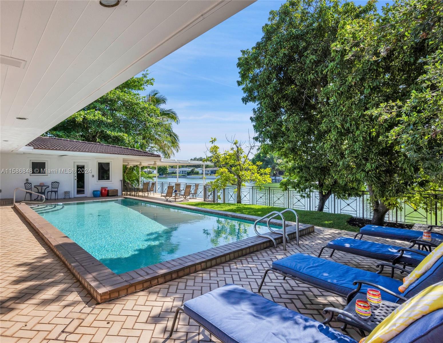 Location, space and natural beauty define this South Miami waterfront gem. The split floor plan w/4 BR (2 ensuite) and 4 BA has a spacious, bright open floor plan. Fun game room w/vaulted, wood ceiling, bar and cabana bath. The 12,000 SF lot w/100 linear feet of Twin Lake frontage features a heated pool, large covered terrace, a porte cochere, large circular driveway and mature fruit trees. A gorgeous, custom metal fence allows stunning water views. French doors in primary suite and living room (both w/ retractable hidden screens) ensures water view are omnipresent- a moment of tranquility by the water is always beckoning!  Impact windows and doors, updated appliances (2023). Mahogany/Tile Flrs.  Owners enjoy robust short term rental income. Quick access to parks, fine shopping and dining.