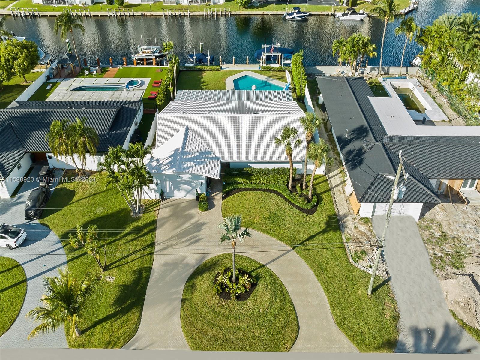 LAND VALUE!! Rent existing home while you design & BUILD your dream home on this oversize lot. Nestled within the prestigious gated community of Golden Isles Estates, this 3 bedroom 2 bath + 2 car garage waterfront home promises a taste of the Florida lifestyle. Centrally located between Miami and Fort Lauderdale, this residence is in close proximity to pristine beaches, world-class restaurants, high-end shops, and entertainment. The property sits on an oversized lot spanning 12,750 sqft, with 85 ft of deep water frontage, no fixed bridges and quick access (~ 25 min) to the open ocean. This property has been meticulously updated inside and outside for avid yachters. The newly renovated dock rests on a batter pile sea wall, features 2 boat lifts, composite decking, shore power and water.