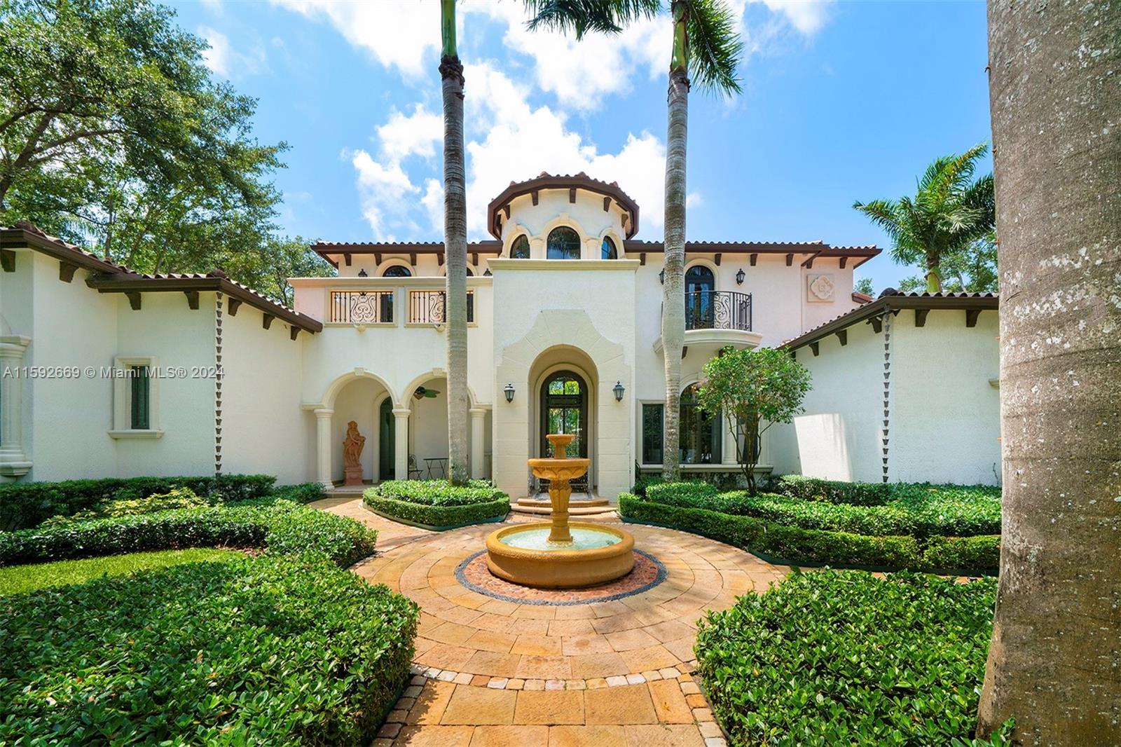 Welcome to this custom 2-story Coral Gables residence. The grand entrance ft. a charming garden w/ a fountain, leading to a majestic front door. Inside, high ceilings & a chandelier greet you to a dining & living area with a fireplace, made w/ hand-crafted natural stones, walnut, & cedar finishes. The space includes a wet bar, wine cellar, & an office/entertainment rm. The expansive kitchen, w/ wood cabinets & marble countertops, opens to a family rm. The laundry rm connects to an in-law suite w/ a bathrm. The secluded primary suite offers a wet bar, a sitting area, private access to the lush backyard, & a bathrm w/ stone finishes, a hidden shower, & vanity. Upstairs, 3 bedrms ft walk-in closets, ensuite bathrms, & balcony access. The backyard ft. a pool, jacuzzi, sauna, & a 3-car garage.