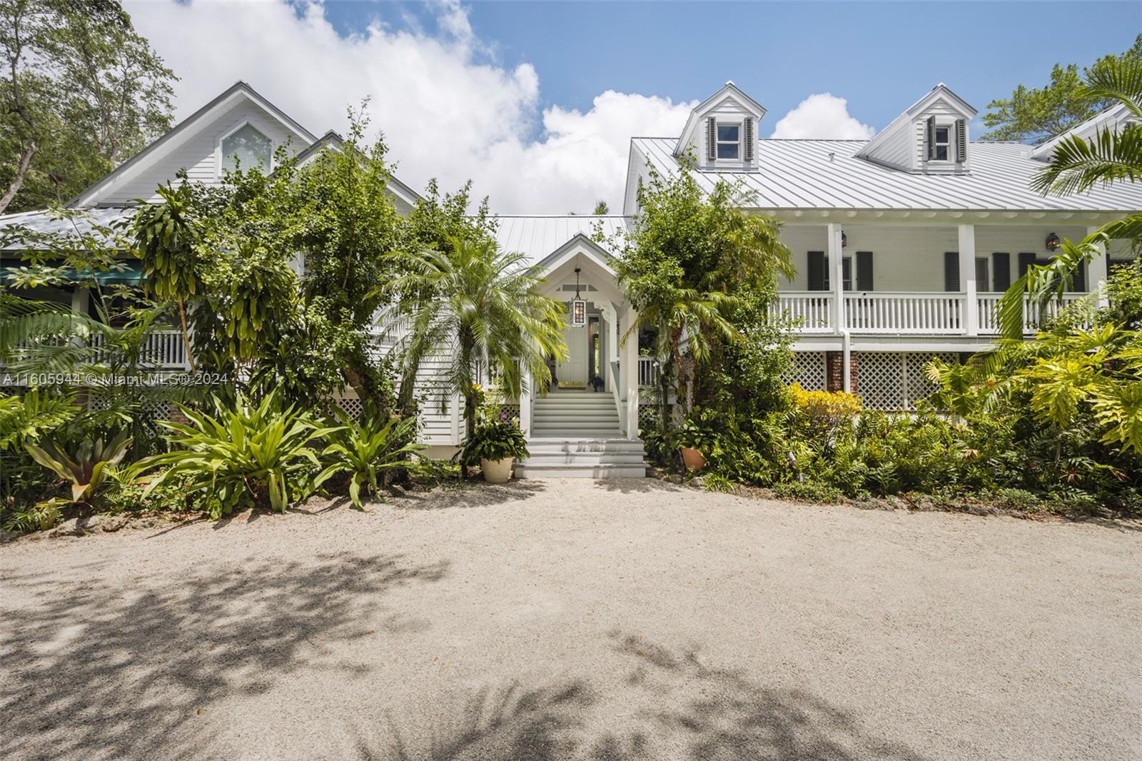 Welcome to paradise! This sprawling residence located in prestigious North Pinecrest offers 6 Beds/6.5 Baths across 5,387 SF of living space, nestled on a lush 40,946 SF lot. The sale includes adjacent 39,988 SF vacant lot, providing a rare opportunity to own a combined 80,934 SF, or nearly 2 acres, of prime real estate. Step inside to discover charming 100-year-old barn wood floors, a grand foyer entry, and vaulted ceilings. The home features a chef's kitchen, breakfast nook, formal living and dining rooms, a wraparound porch, plantation shutters, wine chiller, and so much more. Immerse yourself in an enchanting outdoor oasis complete with a koi pond, pool, mango grove, and impeccable landscaping. Additional amenities incl. a built-in carport w/extra storage, laundry room & maid quarters.