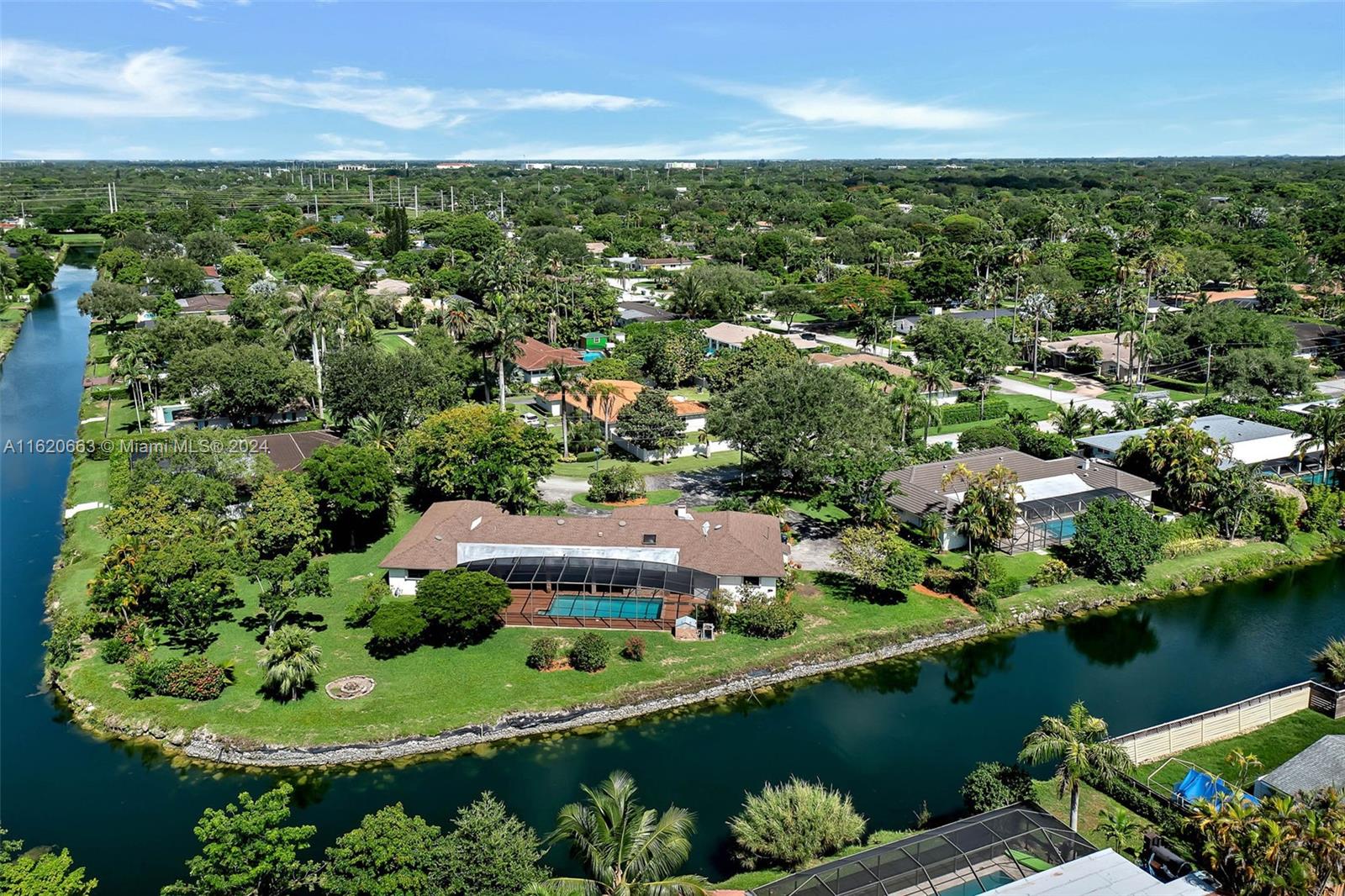 Lovely 5 bdrm, 3 bath home uniquely situated w/ serene canal views from every angle, on an oversized lot in North Palmetto Bay. Great floorplan & square footage, so much potential to update to your taste!  Welcoming foyer entry. Formal living & dining rooms. Spacious family room w/ charming fireplace. Wood & carpet flooring (w/ terrazo underneath). Warm & inviting kitchen w/ breakfast nook, center island, gas cooktop & pantry. Split floorplan w/ a separate junior suite. Indoor laundry rm w/ cabinetry & sink. 2 new AC units. Expansive covered terrace, screened pool & wonderful, private backyard w/ fruit trees & 280 ft of waterfront where you can enjoy freshwater fishing & access to Coral Reef Park & Tanglewood Lake. Circular driveway, 2 car side entry garage plus room to park a boat.