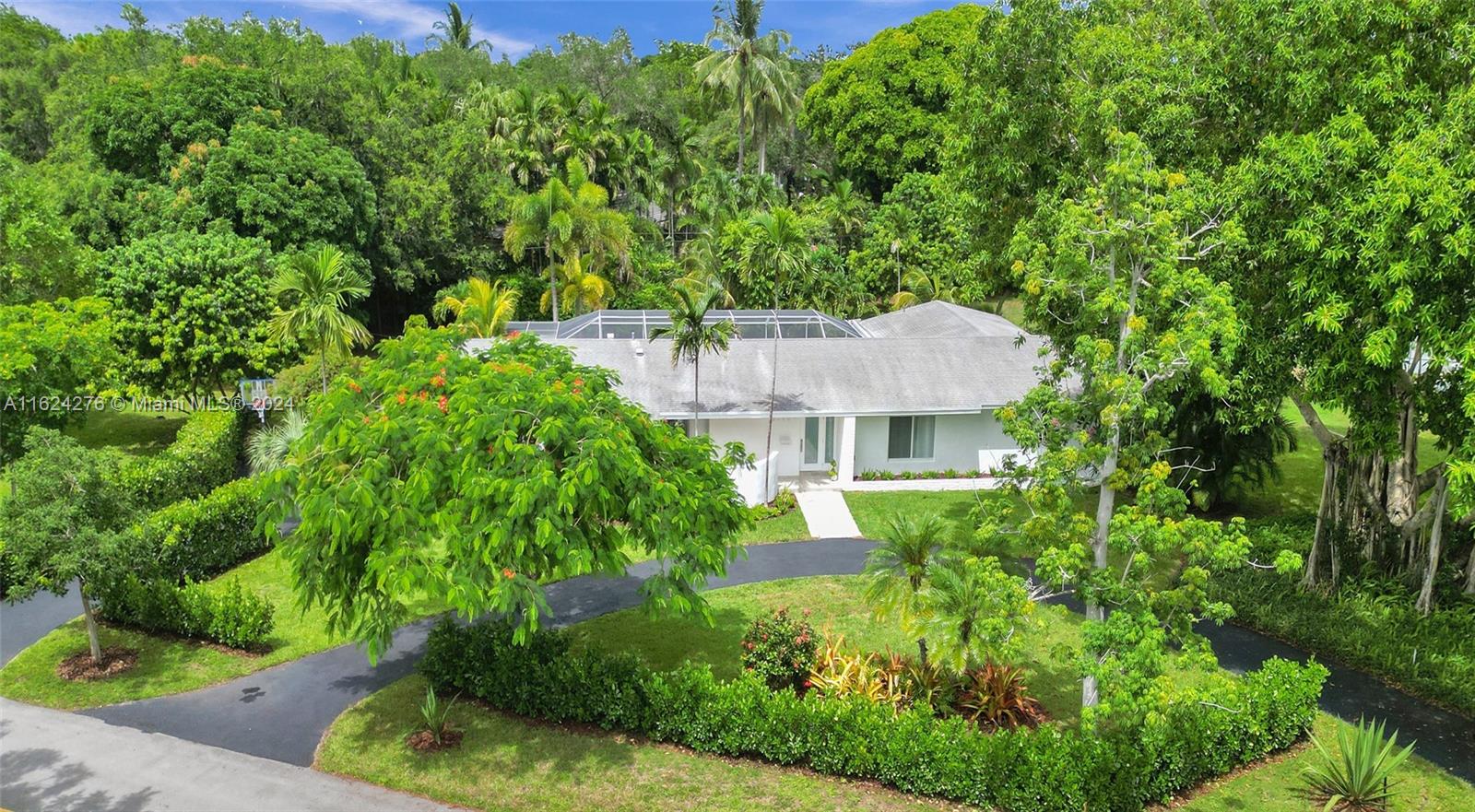 This stunning Art Deco Mid-Century Modern home in Pinecrest is situated on a 3/4-acre lot on prestigious Chapman Field Drive, near historic Old Cutler Rd. The home seamlessly blends modern features with the charm of its original design.  It boasts 36" white porcelain tile floors, an open floor plan, a wall of glass doors, hurricane impact windows and a white kitchen with quartz countertops.  The fourth bedroom features a vaulted ceiling, double entry doors, and an adjoining bath.  The screened patio and pool are visible from all living areas, offering a serene view. The property is beautifully landscaped with a butterfly and hummingbird garden, fruit trees, an extraordinary Banyan tree and various tropical plants. Additionally, the home is located high above the flood plain- no flood zone.