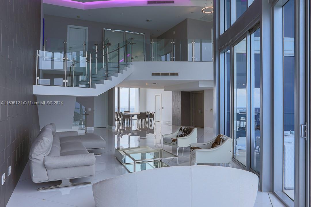 Discover unparalleled luxury at this magnificent Jade Beach Sunny Isles penthouse. This 4,141 SF two-story residence features a private elevator, expansive living spaces, and 22' ceilings. Enjoy breathtaking ocean and Intracoastal views from floor-to-ceiling windows and four terraces. The master bedroom offers two closets and bathrooms, with four additional bedrooms. High-end Miele appliances, subzero refrigerator, coffee maker, and wine cooler enhance the kitchen. Experience full automation for temperature, lighting, and blinds. Amenities include a fitness center, spa, pools, children's playrooms, and beach service. Ideally located near Bal Harbour Mall, Aventura Mall, and top dining options, this property epitomizes luxury and convenience.