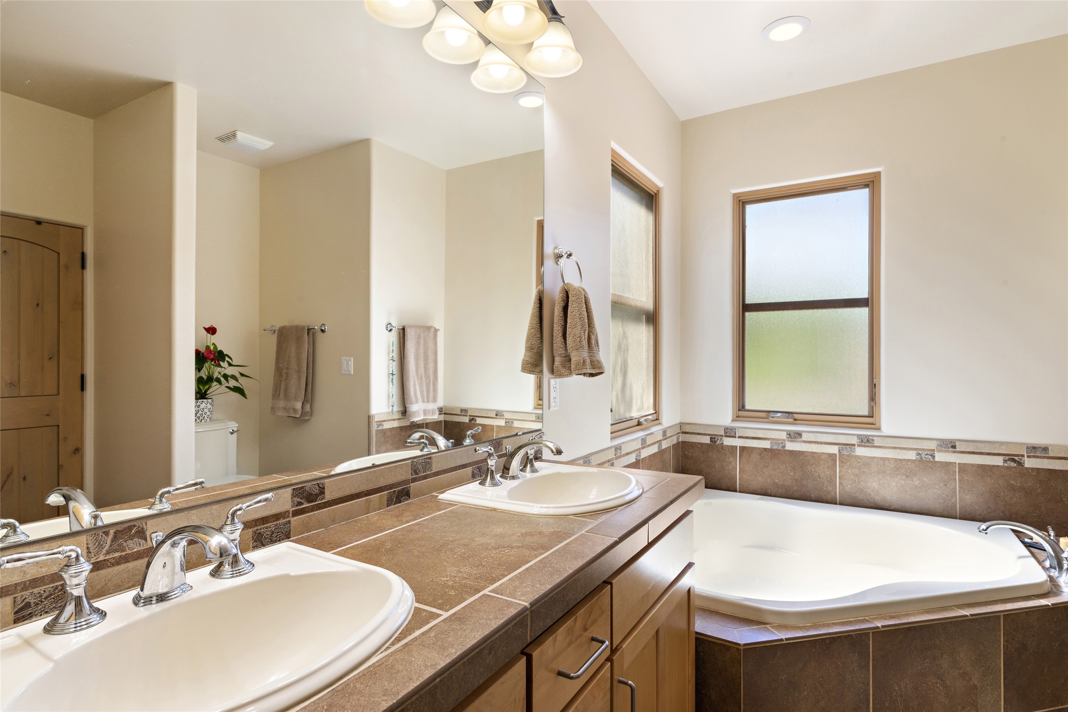 Primary bathroom with double sinks and large corner soaking tub