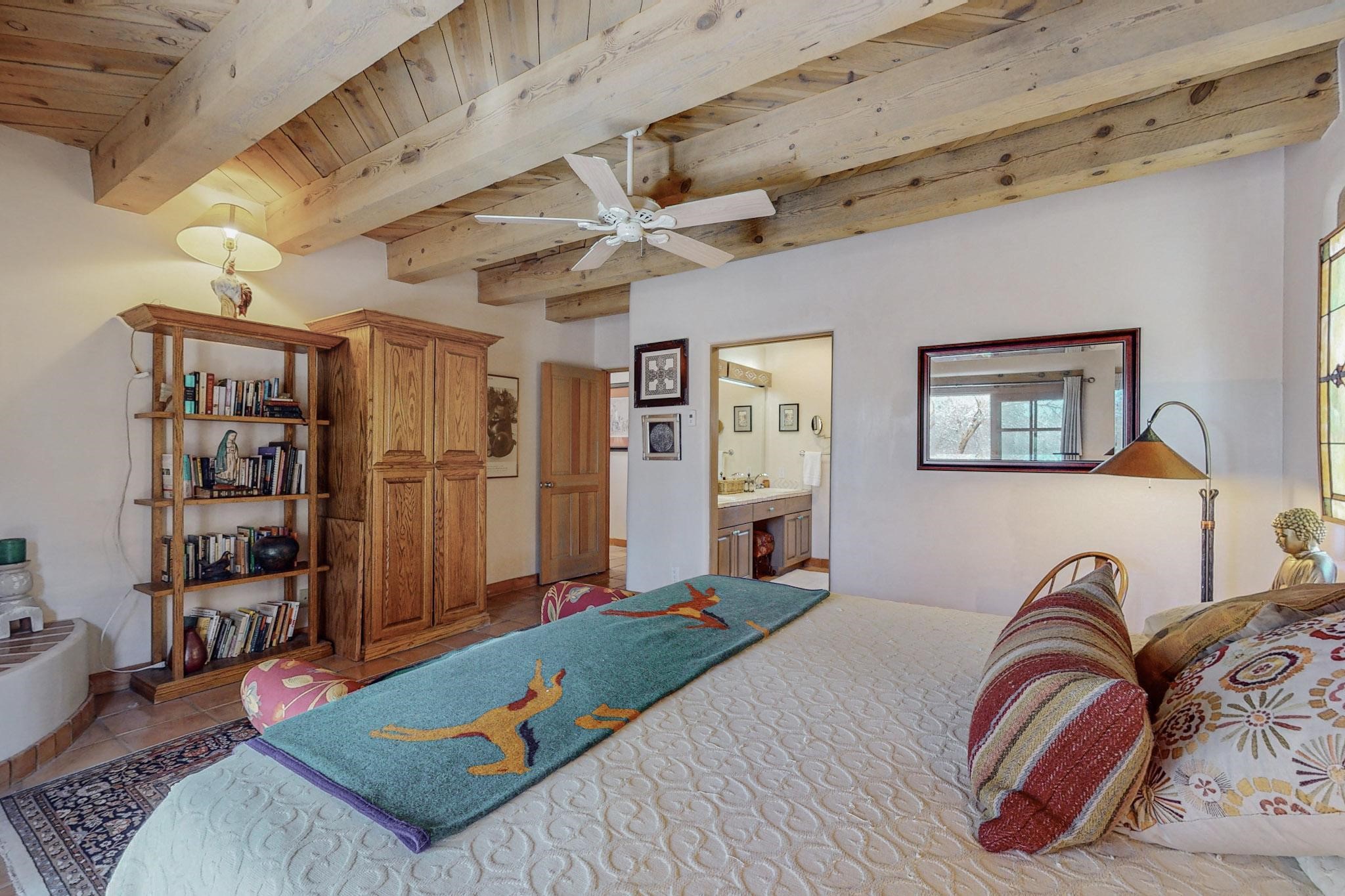 Primary bedroom with ceiling beams with tongue & groove wood planks.