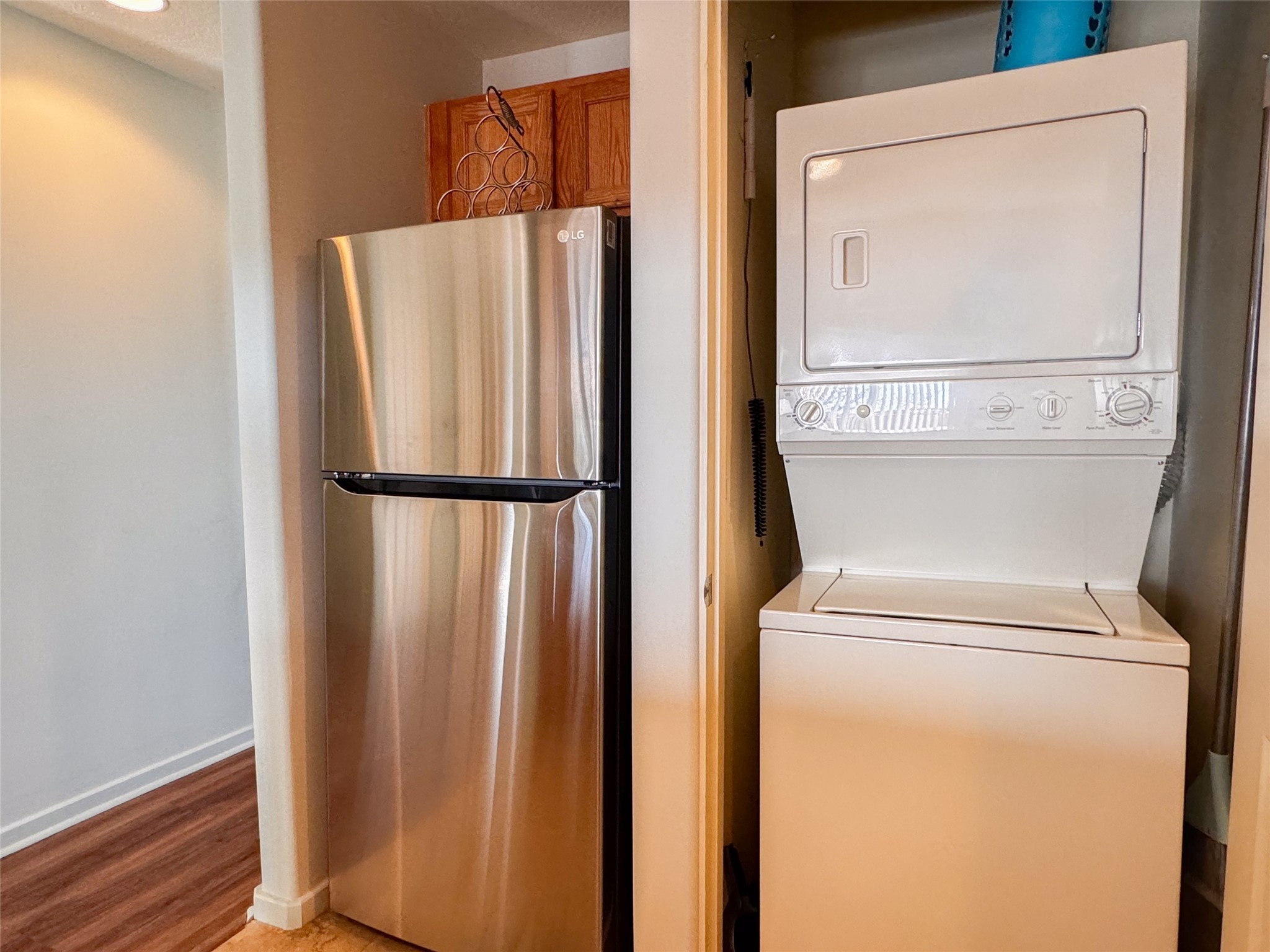 STAINLESS STEEL REFRIGERATOR NEXT TO THE LAUNDRY AREA