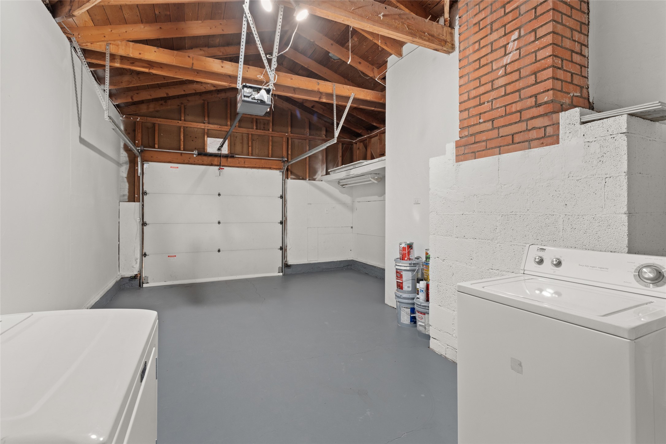 Garage with painted floor, small storage area or shop with washer and dryer