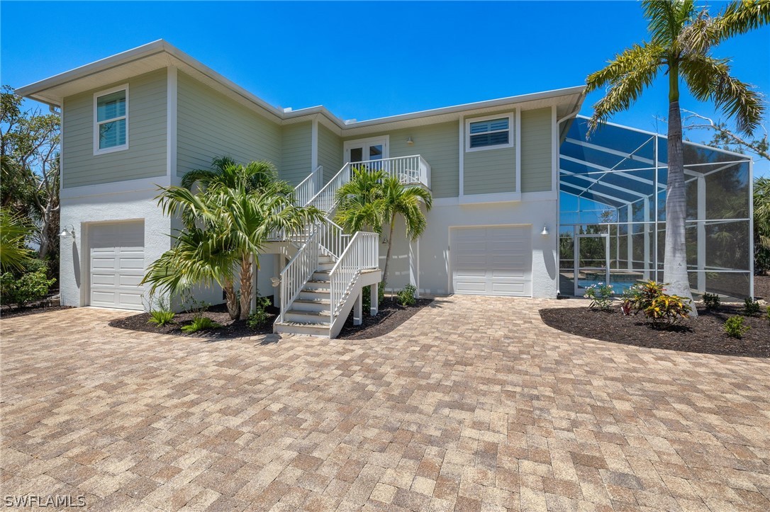 With living area untouched by Ian, this 2017 beautifully constructed near beach pool home is ready to be your new island home! Just across Middle Gulf Drive from the Gulf of Mexico and the renown Sundial Resort with its exceptional dining options and overlooking the Sanibel River and the Sanibel Island Gulf Club beyond, this is a fabulous mid island location. Resident beach access with parking is less than 4/10 of a mile away! A whole house generator, two water heaters, and a private elevator add great convenience and functionality to this impeccably maintained home. The high ceilings of the great room create a wonderful open space enhanced by plentiful windows and lovely natural light. The well appointed open kitchen features soft close wood cabinets, stainless steel Kitchen Aid and Whirlpool appliances, granite countertops and tile backsplash. Custom tile shower enclosures, granite topped vanities and stylish framed mirrors create a spa-like atmosphere in each of the three bathrooms. A lovely private office has abundant windows overlooking the water. The spacious lanai also overlooks the water and has accommodating access to the pool area and lower level bonus space. From the bright entry of the inviting foyer to the pocketing sliders that blend the indoor and outdoor living areas, this gorgeous furnished home offers the peace of mind and lower insurance costs of newer construction, excellent near-peach location, privacy, and water views.