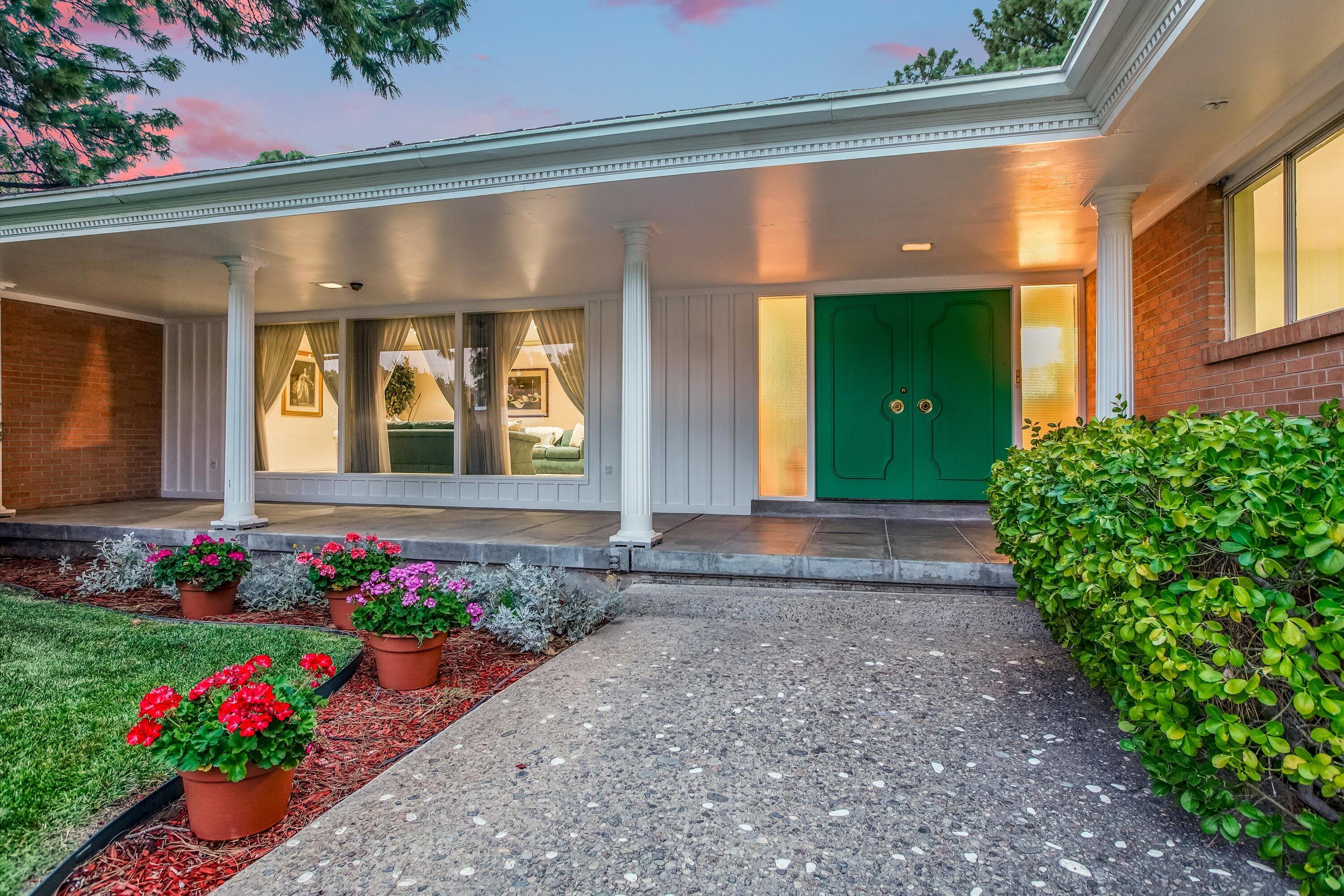 A hidden gem & one-of-a-kind property in Albuquerque's desirable Ridgecrest area.A true palace set on a generous lot with mountain views, lush yard with a flowing waterfall pond and mature trees. This home is awash in luxury and opulence. Starting with a grand entryway, terrazzo floors and hand painted 14K gold accents. The living room is expansive, with raised-panel Honduras mahogany built-ins and a fireplace. The formal dining room is equally impressive, with a striking chandelier and designer fabric wall coverings. The kitchen is a chef's dream, with loads of mahogany, finished maple cabinets, shimmering countertops, brand new SS appliances and a breakfast nook with beveled glass windows to show the views. The primary suite is fit for a king or queen.