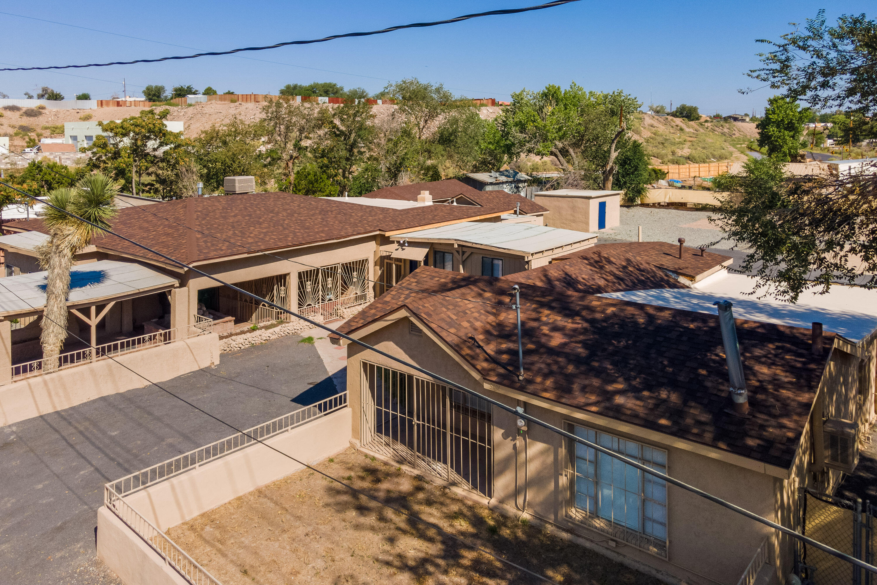 NEW PRICE.  Two houses, one studio in this Southwest Adobe compound, NEW ROOFING INSTALLED  ON BOTH HOUSES SEPTEMBER 2024 Main house has 5 bedrooms, 2 bathrooms. The kitchen, with new cabinets, granite countertops, stainless appliances, join a family dining room with attached sunroom, and a separate large family room with custom fireplace. The casita, and a studio are renovated with new tile flooring and carpet. There is also a garden office, and a huge storage shed.  Marble floors in the bathrooms, upgraded HVAC, new mini-splits, new electrical, upgraded plumbing, new additions to the front and back; all in 2023, complete the renovation.  All accessory buildings are heated and air conditioned.  This half acre lot has room for RV parking or gardens.