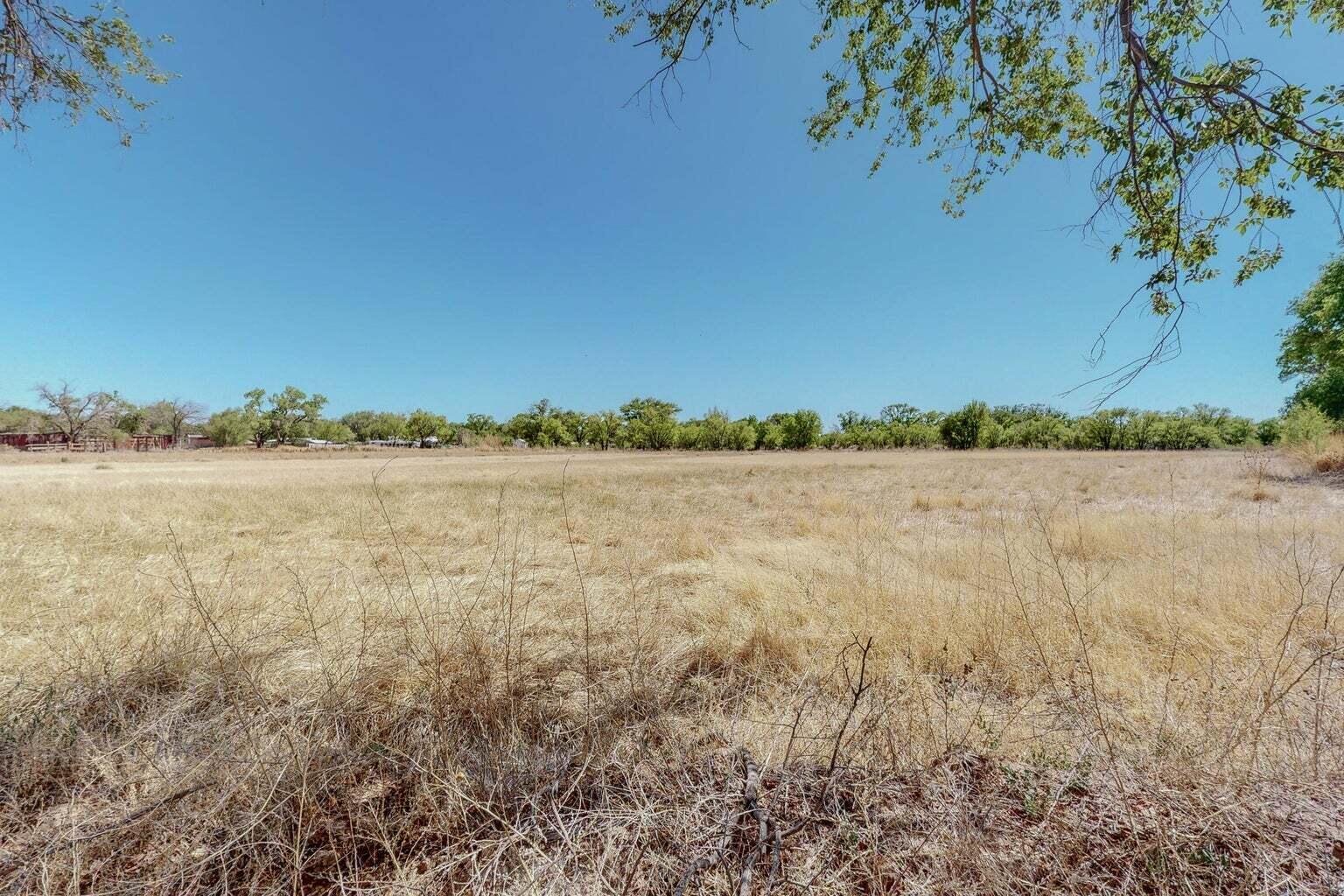 Imagine living in a beautiful country setting neighborhood amongst the tree lined meadow, perfect for Horse Lovers! Don't miss this great opportunity to have 18 acres of prime land nestled in the heart of the south valley. Make your dream come true to build your custom home, have some livestock, or cultivate the land. Perfect for an investor to possibly subdivide and build to suit as well. Enter the property by the larger real estate sign at the NW corner stay on the path to the right side of property Drive ONLY on this path. DO NOT DRIVE ACROSS HORSE TRAINING AREA WHERE SOFT DIRT AND BARRELS ARE PLACED The land is level and can be easily walked. Ditch irrigation is possible through NMRGC.