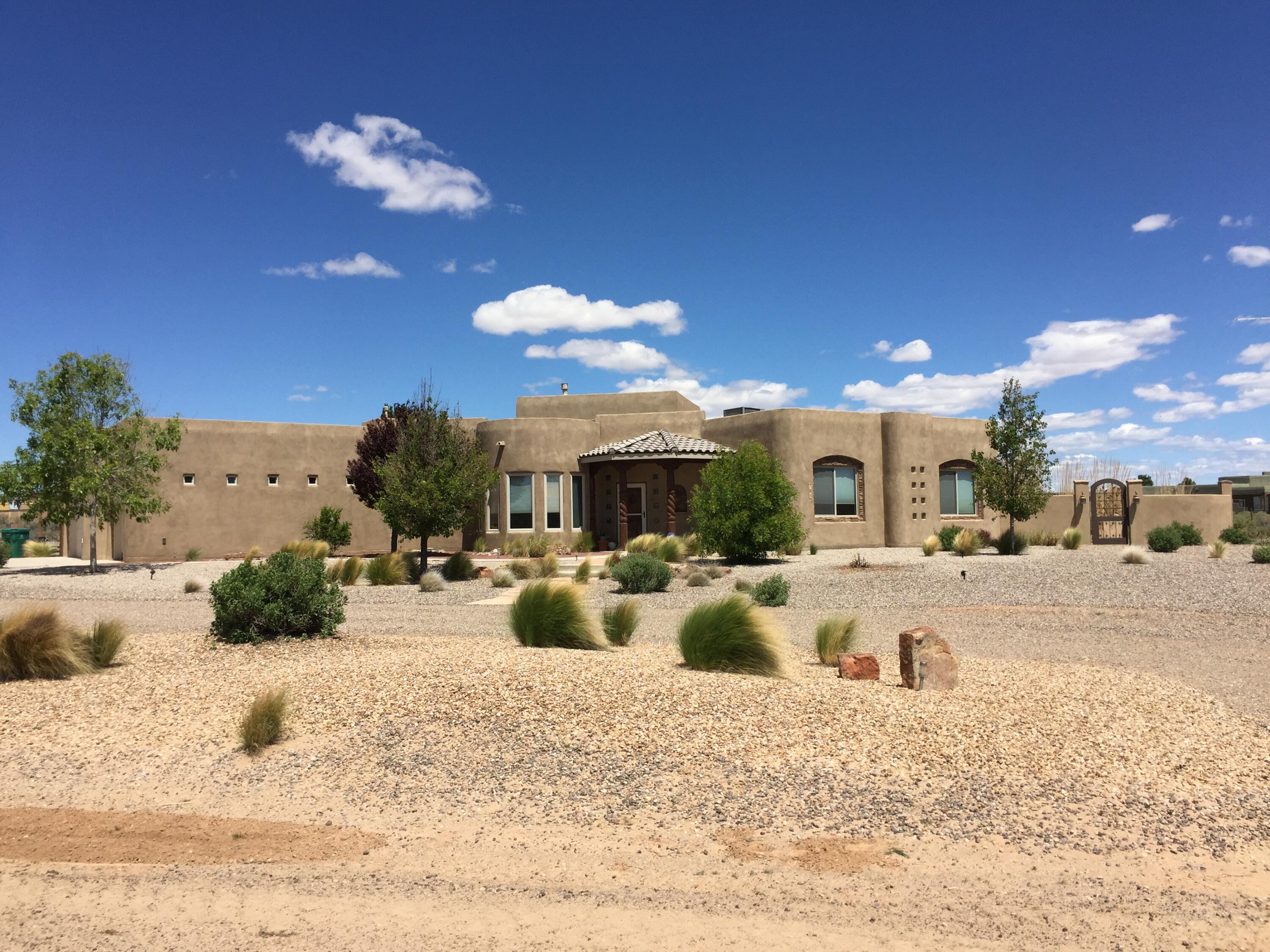 This beautiful custom home sits on an acre and has stunning mountain and sunset views! The home features a 14ft vaulted ceiling w/hand-carved wood beams, kiva fireplace, tile medallions & variance wall finishes throughout. Large gourmet kitchen features custom cabinets, double ovens & two islands! The owner's suite has two vanities, large walk-in closet, jetted tub, snail shower and access to the patio. The fully landscaped yard with over 1,300 sqft of terrace & patio space, pond and an outdoor kitchen is an entertainer's delight!  Huge 2,400 sqft (40'x60'x16') insulated RV garage/shop with concrete slab has a 14ft tall RV door and a 2 car garage door. Home is energy efficient w/high R-values and recent spray foam roof.