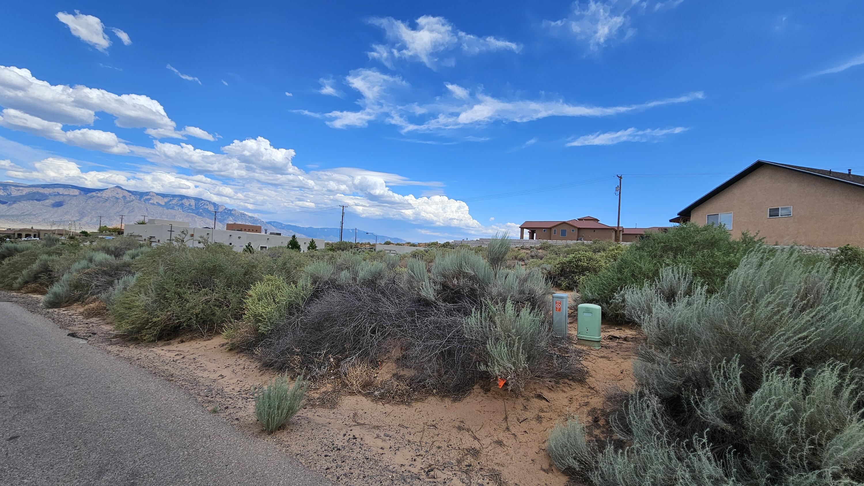 Great shaped lot on a paved street ready for your new home! This lot sits between two beautiful homes among custom homes. Gas & Electric are in the street here, must drill a well and add septic for your home. This neighborhood adjoins Corrales and many refer to the area as Corrales even though it's Rio Rancho.  Rio Rancho prices with Corrales feel. Close to shopping and restaurants.