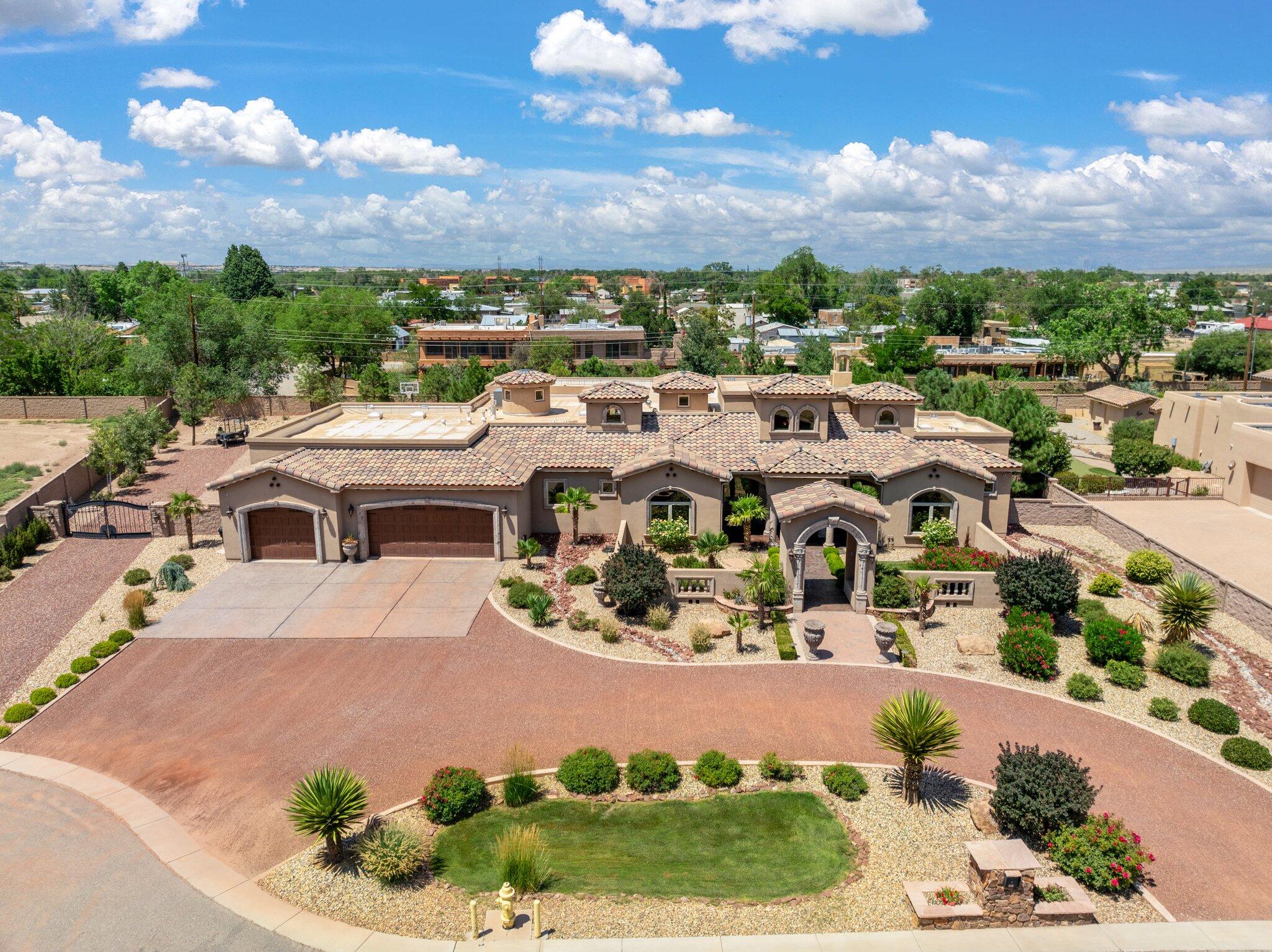 Indulge in the opulence of this impeccable Mediterranean style masterpiece, tucked away in the North Valley on a sprawling .75 acre property. Grand entryway with Cantera stone columns and travertine floors that flow seamlessly. Elegant living area with a cantera stone fireplace, nichos, built-in cabinetry and a raised ceiling lined with wood beams. Gourmet kitchen is a chefs dream hosting designer cabinetry, chiseled edge granite countertops, high-end appliances, prep island, bar with seating and a pantry. Luxurious owners retreat providing a true spa experience. Bath hosts his/hers vanities, a large tub with fireplace, amazing shower providing serene ambience and a walk-in closet! Gated side yard access leads to a fully landscaped yard, covered patio w/ grill and basketball court!