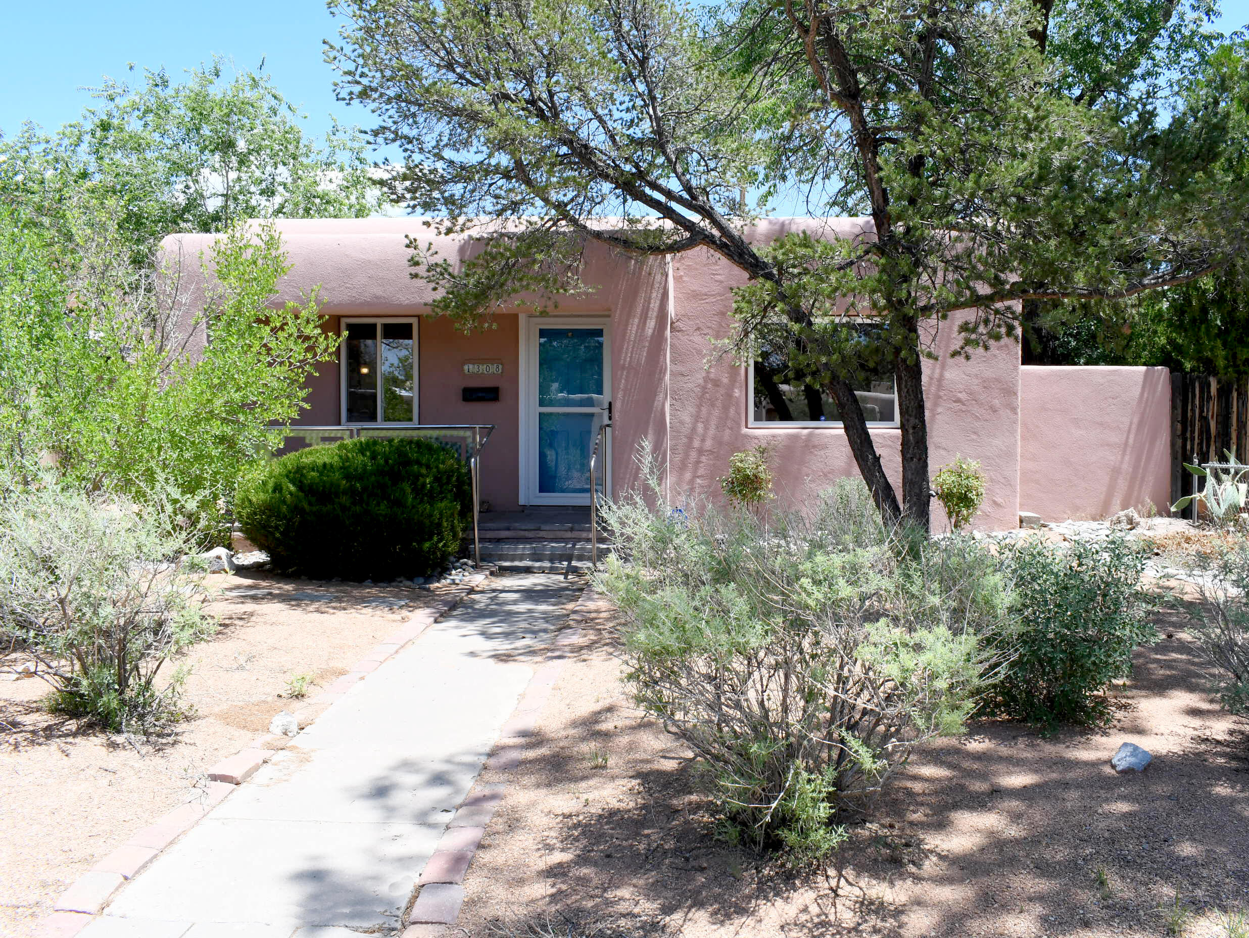 Charming North Campus location! This pueblo style  home has updates to the kitchen and baths. Newer vinyl windows, replaced front and rear doors, ceiling fans, and a TPO roof. This comfortable house also features two living spaces flooded with natural light from windows and skylights. The family room includes a charming sun room for plants or curling up with a favorite book. There is a private rear yard with an enclosed patio, and low maintenance front yard.  Abundant storage and an attached one car garage accessed off Girard. Nearby the UNM medical and law schools, the North Golf Course, parks, Whole Foods, and neighborhood restaurants. Super location. Hurry, this is a special home!