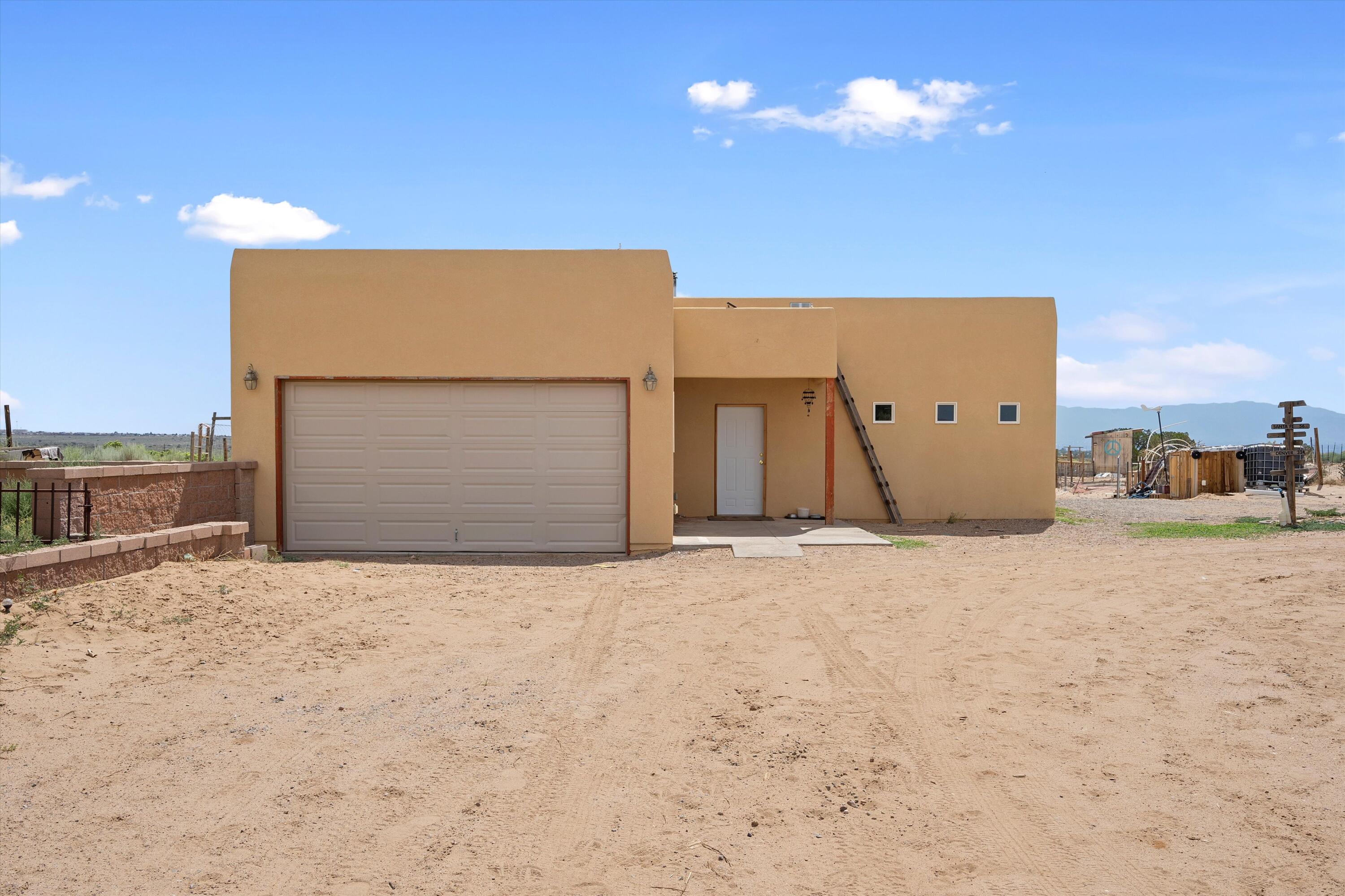 Escape to this unique, off-grid home nestled on a serene .90-acre lot in Rio Rancho, offering both privacy and convenience. This 4-bedroom, 2-bathroom stick-built property features a wood-burning stove, solar/battery-powered appliances, and essential off-grid systems including owned propane, hauled water, and a septic tank. Perfect for sustainable living enthusiasts, the property also includes a chicken coop for your feathered friends. While currently self-sufficient, there's potential for future connections to PNM and NM Gas. This property combines rural charm with proximity to city amenities. Currently there is NO ELECTRICITY, no solar panels, no water trailer, water pump, or plumbing to move water from the IBC totes into the house. CASH or REHAB LOAN (203K) ONLY.