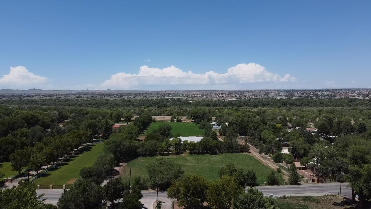 This property beckons with 7.8 acres of rural serenity along Rio Grande Boulevard in Los Ranchos de Albuquerque. Despite its idyllic countryside setting, surrounded by farms and equestrian facilities, the property offers seamless access to the City of Albuquerque and Rio Rancho. Boasting 302' of frontage on Rio Grande Blvd, it extends west to the Paseo del Bosque Trail and the Rio Grande River. With an existing, uninhabitable dwelling and storage building, the site presents a golden opportunity for redevelopment. Envision a grand single-family estate or multiple unique north valley homes, blending tranquility with proximity to urban amenities. This is your chance to create an extraordinary living experience at 7601 Rio Grande NW.