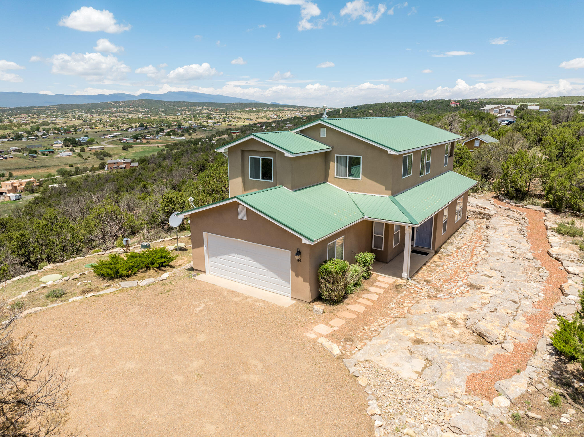 This stunning property offers incredible views & magnificent sunsets that paint the sky in vibrant colors. The home is surrounded by native, low-maintenance plants, ensuring a beautiful yet easy-to-care-for landscape. Enjoy ultimate privacy between neighbors in this serene, rural environment just 30 minutes from Albuquerque, where cooler temperatures provide a refreshing escape. The spacious home features 4 bedrooms, including a convenient main-level suite, & tons of storage space. Additionally, there's a versatile workshop perfect for storage or projects. Meticulously cared for, this home comes with a generator and a one year home warranty for the buyer! The lot to the north is for sale too - consider building for a family member next door!