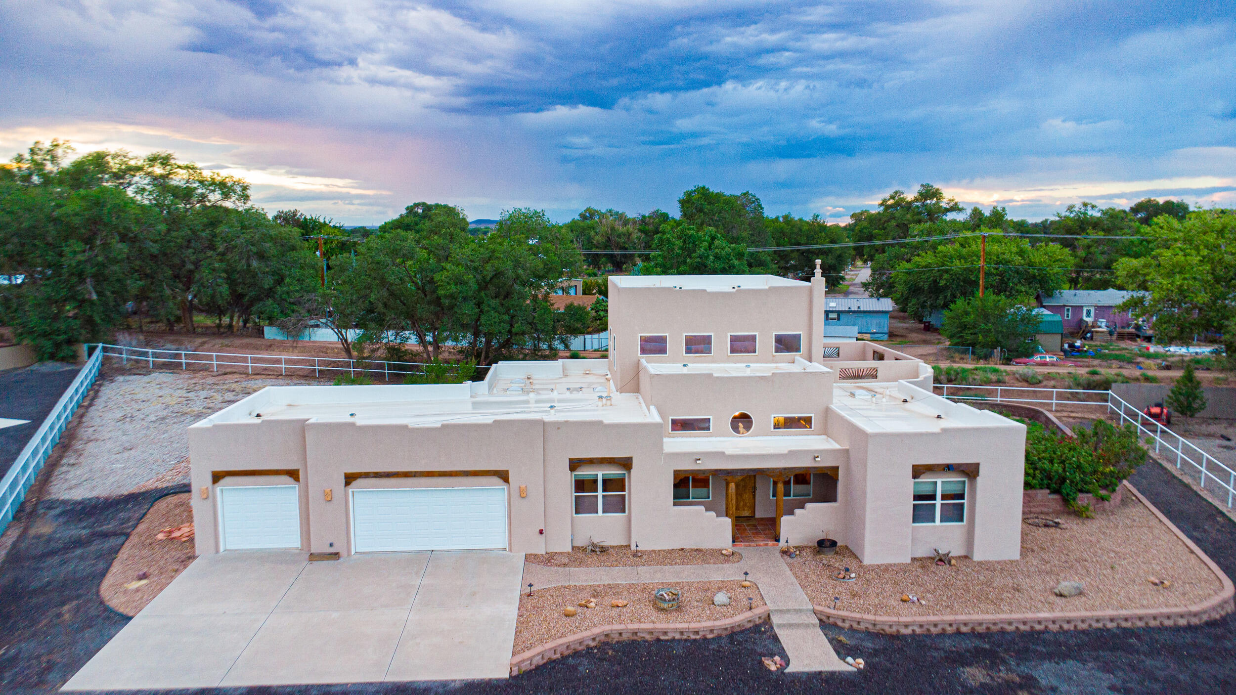 Experience luxury in this custom Spencer Wood built home. Set on a sprawling, meticulously maintained property, it offers privacy and stunning mountain and Bosque views. Enter through electric gates to a black lava rock driveway and a charming brick garden. Cascading steps lead to a front porch with custom lighting. The southwestern-style courtyard features arched wooden gates opening to a grand covered patio with wood ceilings, vigas, and BBQ area. Inside, the open kitchen boasts stainless steel appliances and granite countertops, large primary suite and bedrooms. Surrounded by lush fruit and ash trees, the home includes abundant indoor storage, a grand foyer with a waterfall, an open kitchen, and a kiva fireplace. Oversized 3 car garage for all your storage needs.  Come take a look!