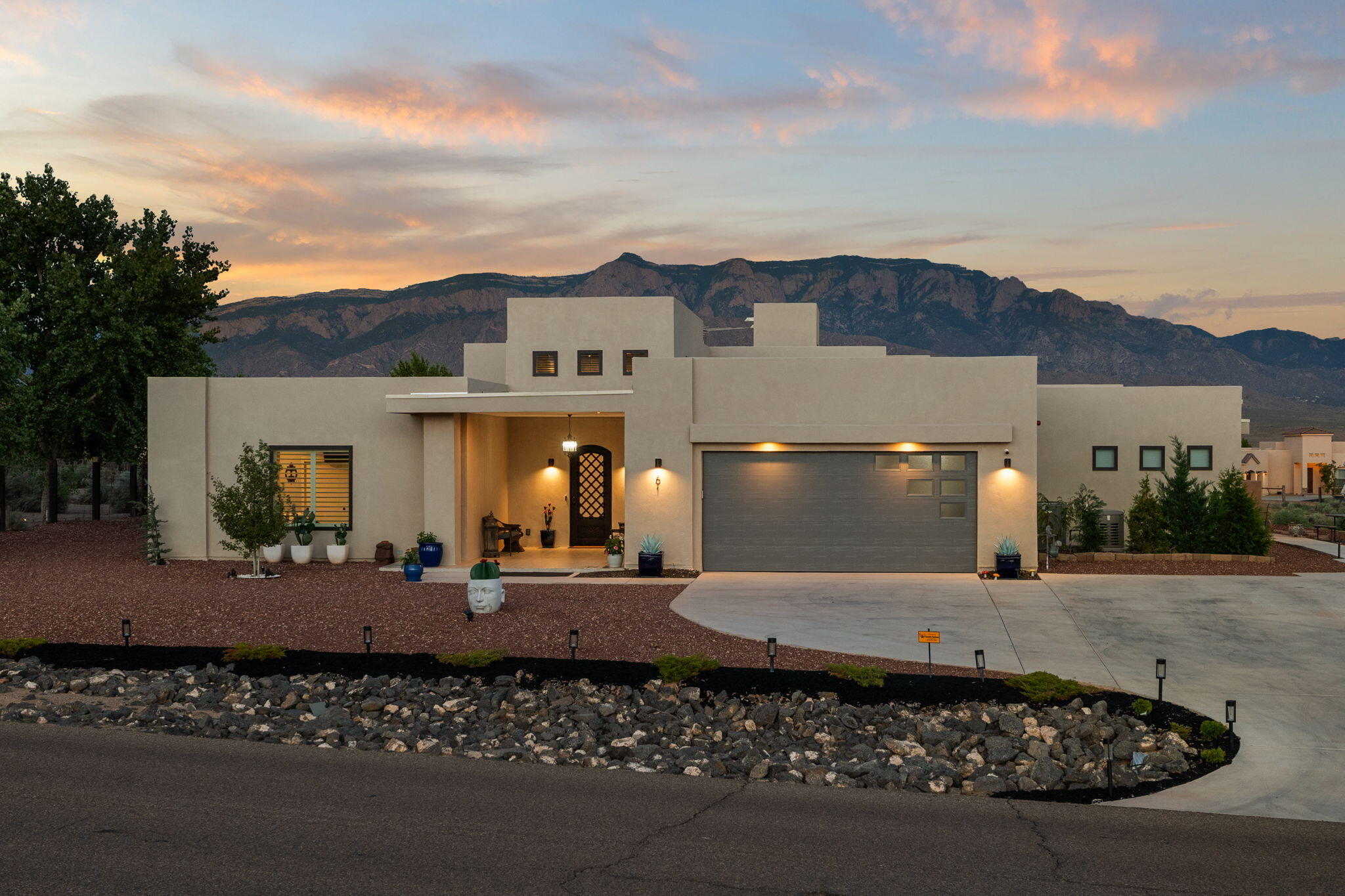 Breathtaking views welcome you to this custom built single story home, designed to emphasize the unparalleled Sandia Mountain sunsets.  Priced at $175,000 below appraisal, this open concept living space features soaring ceilings with skylights, custom window coverings, large sliding glass doors and a stunning floor to ceiling fireplace. The kitchen offers the perfect blend of style and function, with a sprawling central island, granite counters and 2-tone cabinets. The primary suite includes a secluded patio, luxurious bathroom with radiant heat flooring and a spacious walk through closet. The secondary bedrooms share a Jack and Jill bathroom and a private patio. The attached apartment includes a full kitchen, bedroom, bath and washer/dryer.