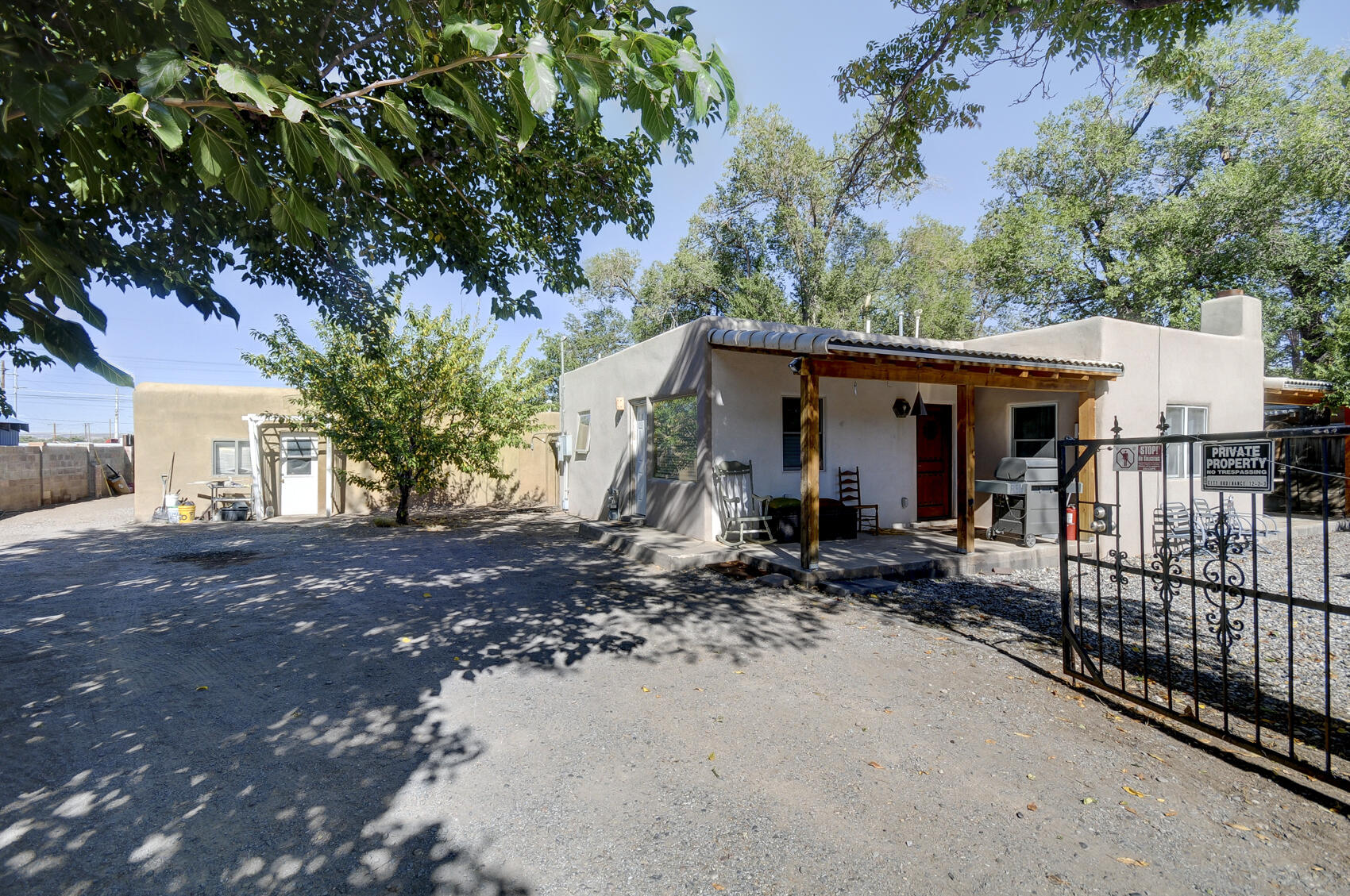 Charming North Valley Home on Half-Acre Lot!Welcome to your dream home in the historic Stronghurst neighborhood! This desirable New Mexico-style residence sits on a rare half-acre lot, complete with vibrant fruit trees and irrigation. Enjoy the outdoor space with two covered patios perfect for relaxing or entertaining. Inside, you'll find modern granite countertops in the kitchen, stunning hardwood floors, and warm wood details throughout. The property also features an additional dwelling unit that presents a fantastic opportunity for transformation into a mother-in-law suite or rental unit. Has plumbing and electrical kitchen, bathroom, and laundry.  needs finished build out.  Don't miss out on this unique opportunity in North Valley!HOA Covers weekly irrigation.