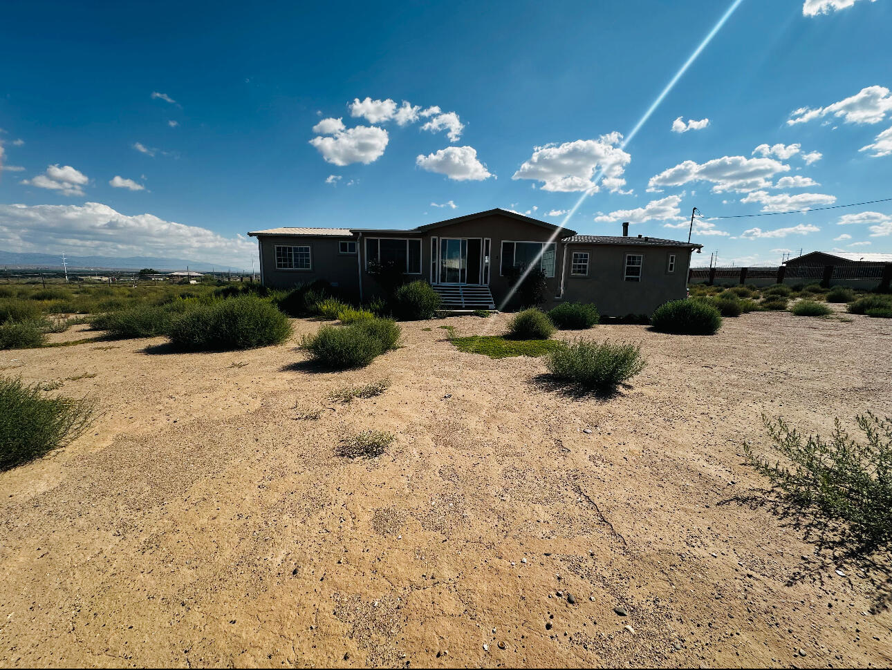 Nestled on 1.26 scenic acres, this stunning home on a permanent foundation offers breathtaking views of the Sandia Mountains. Perfectly located just 3 minutes from the vibrant Las Estancia shopping center, enjoy the best of serene living with urban convenience right at your doorstep