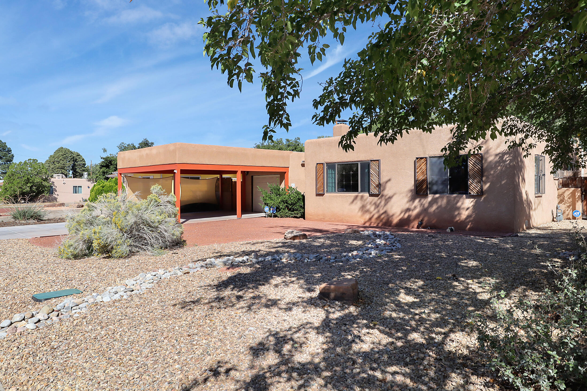 Experience desert-inspired luxury in this thoughtfully remodeled 4-bedroom, 2-bathroom Pueblo-style home, stylishly updated with the colors of the desert. Two expansive living areas provide perfect spaces for family gatherings and entertainment. Recent upgrades include comprehensive plumbing overhaul, modern A/C system, and structural additions. The new carport shields vehicles from intense desert sun, while the spacious back porch creates an ideal outdoor living space. Location offers easy access to Sandia Labs, UNM, and major medical facilities. Solar panels offset monthly energy costs. Move-in ready with over $100k in improvements.