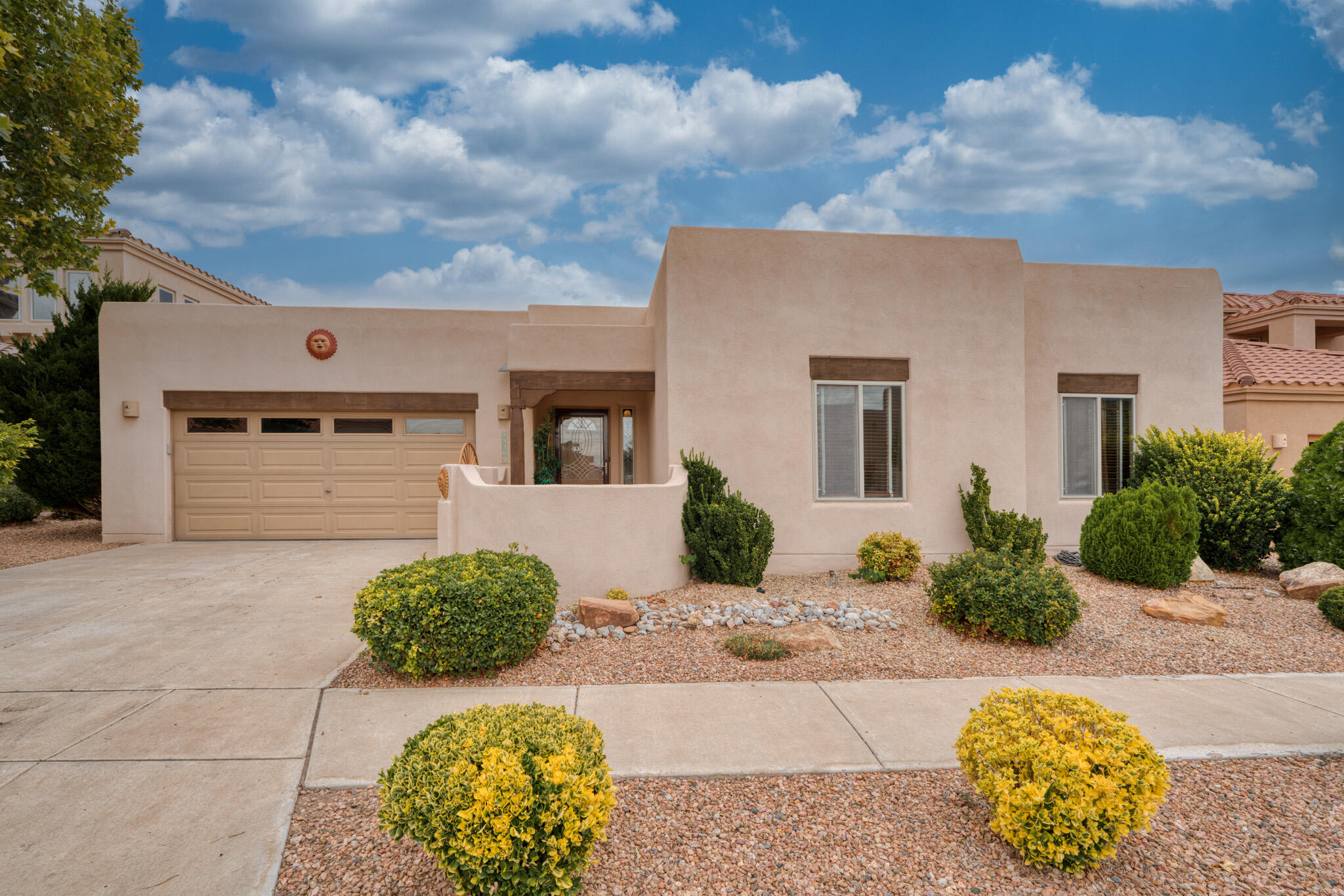 Charming former model home in the desirable gated Oxbow North community! This one-story gem sits on a premium view lot near the scenic Bosque. This lovely 3 bedroom, 2 1/2 bath home features updated flooring, refrigerated air, water softener, kitchen with stunning granite countertops, rich cherry cabinets, large pantry and breakfast nook. Perfect for entertaining, the living space offers an ambient fireplace and opens to a backyard with low-maintenance landscaping, two covered patio areas, and unobstructed views of the Sandias. The spacious primary suite boasts a large walk-in-closet, tray ceiling, double sinks, separate tub & shower, plus a bonus area ideal for a second closet, exercise room, or office.  Beautiful custom murals and paintings can be easily changed to suit your style.