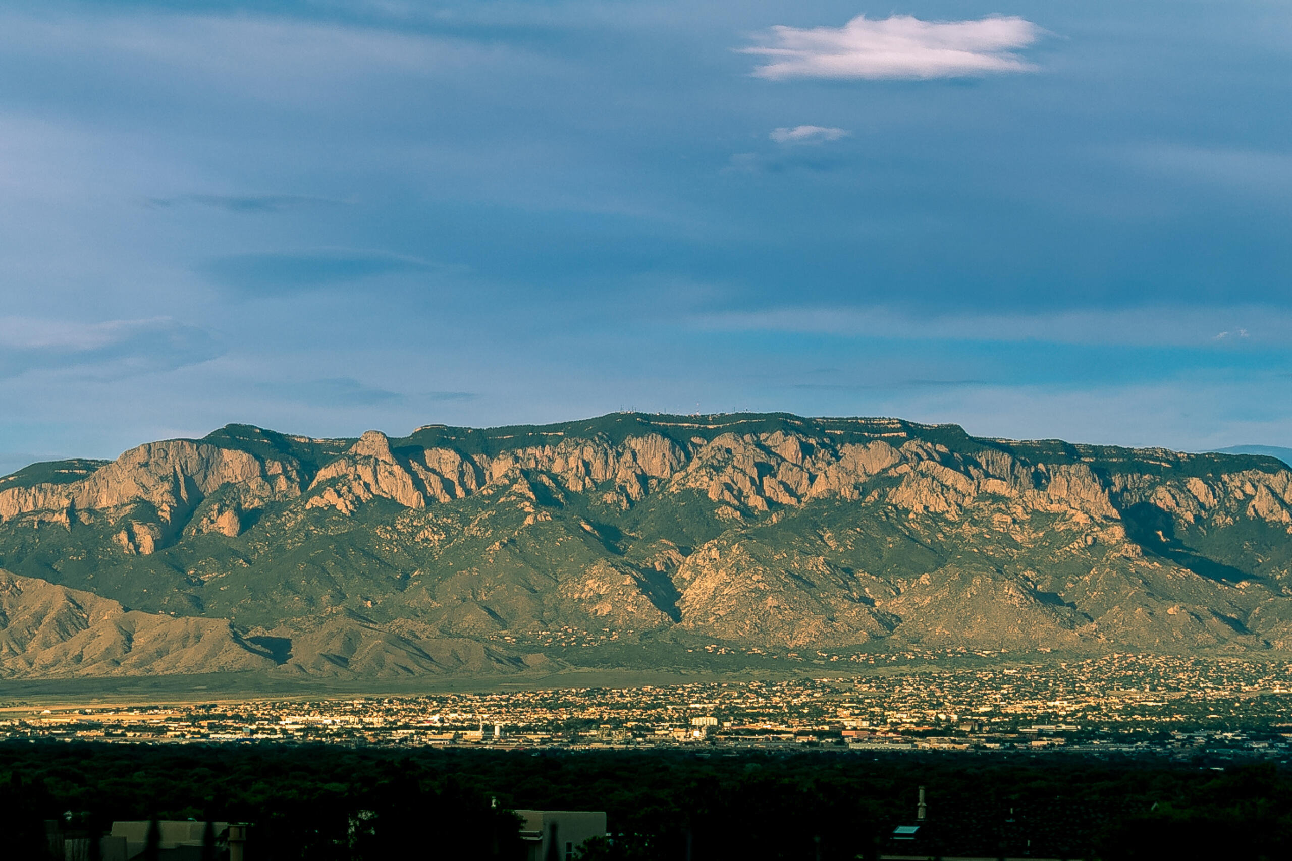 Discover the unique charm of this one-owner home, custom-built by the original homeowner, with breathtaking views of the Sandias and the city from its position on the bluffs. The backyard is a gardener's paradise with apple, peach, and other trees, including a rare Arkansas Black apple tree, plus a garden area ready to bloom with some TLC. Enjoy 2 large living areas with stunning mountain and city views, a large patio overlooking the river valley--perfect for entertaining--and a flex room ideal for crafts or a home gym. The attached area with 2 bedrooms, baths, and a sitting area is perfect for in-laws. New septic tank just installed. The kitchen, remodeled about 20 years ago, features granite countertops and opens to two living spaces with character details like