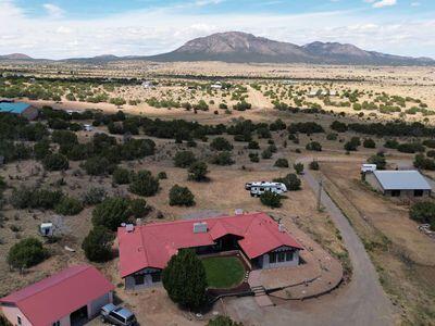 Welcome to your dream home in the serene and picturesque East Mountains. Nestled among the rolling hills of Edgewood, New Mexico, this stunning property offers the perfect blend of modern luxury and peaceful countryside living. With 5 acres of wooded land at the end of a quiet road, this home is a true oasis for those seeking tranquility and space for horses or other animals. Expansive Living Spaces: Step inside this thoughtfully designed home and be greeted by its generous open floor plan, creating an inviting and airy atmosphere throughout. The spacious living room with large windows allows natural light to flood in, highlighting the beautiful architecture and providing stunning views of the surrounding landscape.