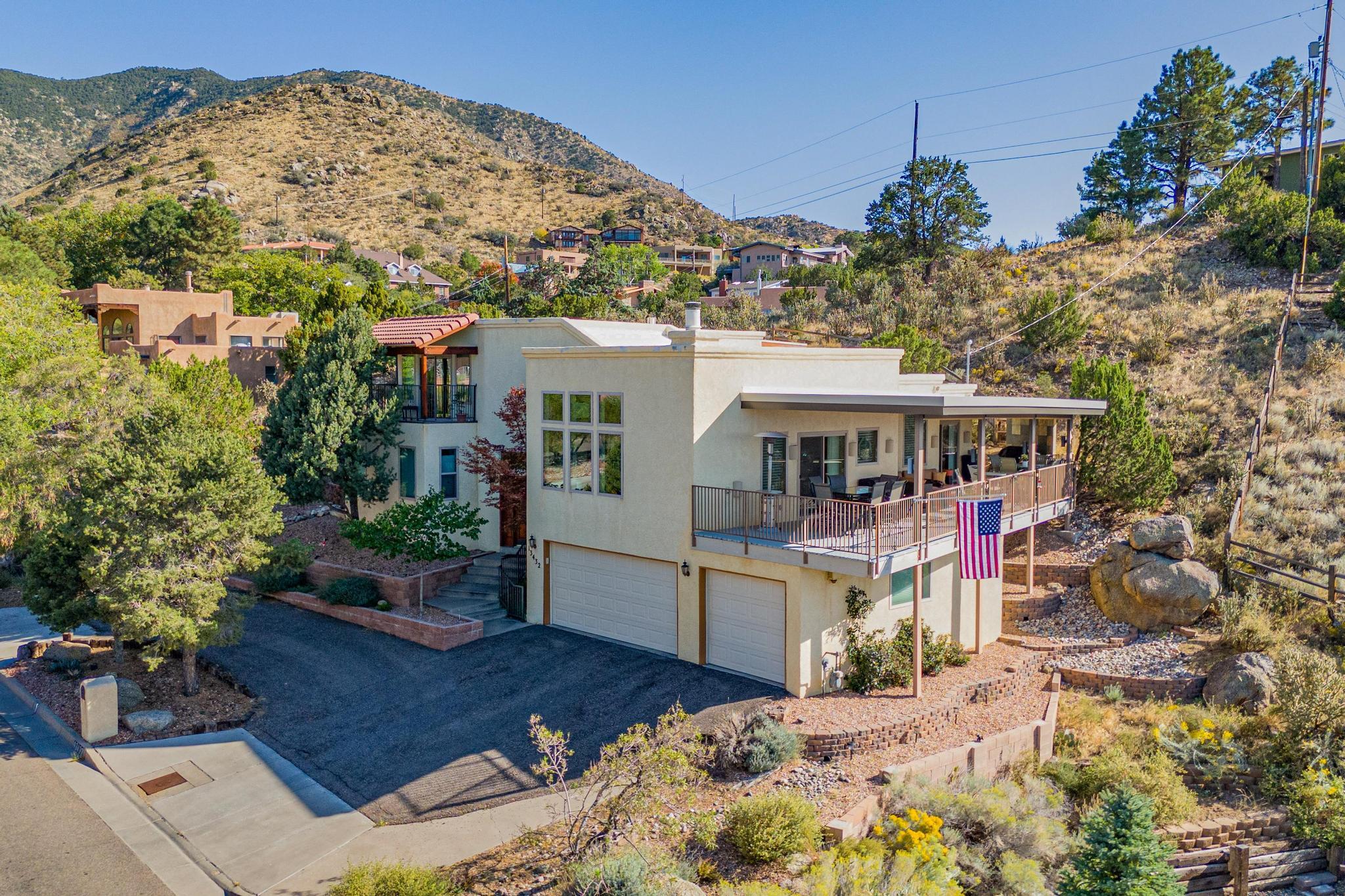 This charming home at the base of the Sandia Mountains features a deck designed to capture the beauty of Albuquerque's majestic mountains & vibrant sunsets.A nature trail,frequently used by local deer,crosses the upper southern portion of the lot.The primary suite features a private deck,en-suite w/soaking tub,dual sinks & large walk-in closet.The home also offers 3 additional generously sized bedrooms.The kitchen is equipped w/stainless steel appliances,dual ovens & gas cooktop.Off the primary bedroom, you'll find a relaxing hot tub room with sliding doors that open to another patio,perfect for unwinding.Enjoy cozy nights in the living room with gas fireplace and a built-in bar, all while taking in panoramic views of the city and surrounding mountains. Million $ Views.See it Today!