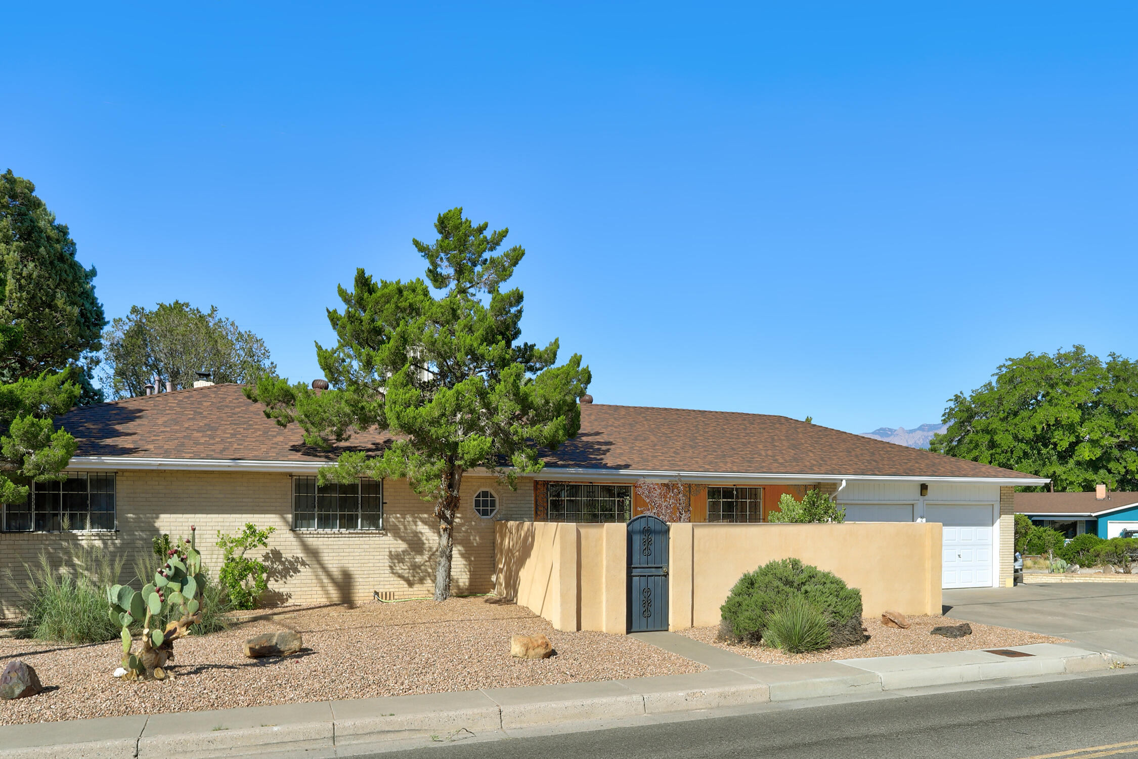 Immaculate Mid Century Ranch near Altura Park, UNM, & Nob Hill! The private courtyard entry welcomes you to this spacious brick beauty! Enter to find Gleaming Original Hardwood floors thru-out, 2 inviting light filled living areas, 3 large bedrooms, 3 baths & storage galore! The kitchen offers beautiful quartz counter tops & brand new stainless appliances with lovely mountain views from the kitchen sink which also looks out to the big backyard & a huge covered patio where you will surely want to spend lots of time! This gorgeous home is sparkling clean with a fresh coat of paint, huge laundry room, oversized garage with workshop area, beautiful easy care landscaping, a circle drive w lots of parking, and convenient access to I-40 and all the UNM area has to offer! You will love this home!