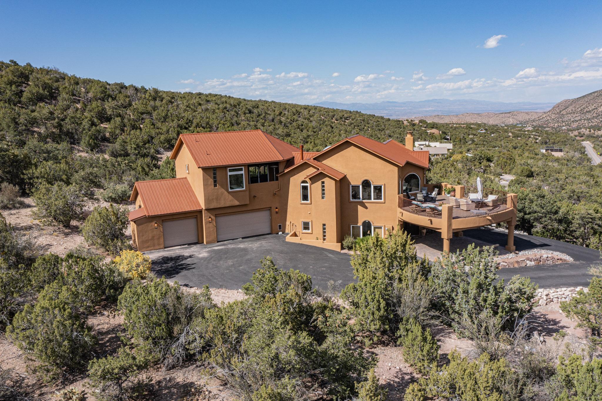 This gorgeous custom-built home sits on 4.88 wooded acres and backs up to thousands of acres of national forest land. No expense was spared on this home including the kitchen which boasts Madagascar labradorite counter tops, Sub-Zero appliances, and a butlers pantry. The primary suite is on is own floor and has a fireplace, full spa like bath, walk in closet and private balcony. The lower level has a 600sqf family room with 2 bedrooms and a full bath which is perfect for kids or company. The abundant outdoor decks are made of Trex for low maintance and year round usage. Don't miss this one of a kind masterpiece.