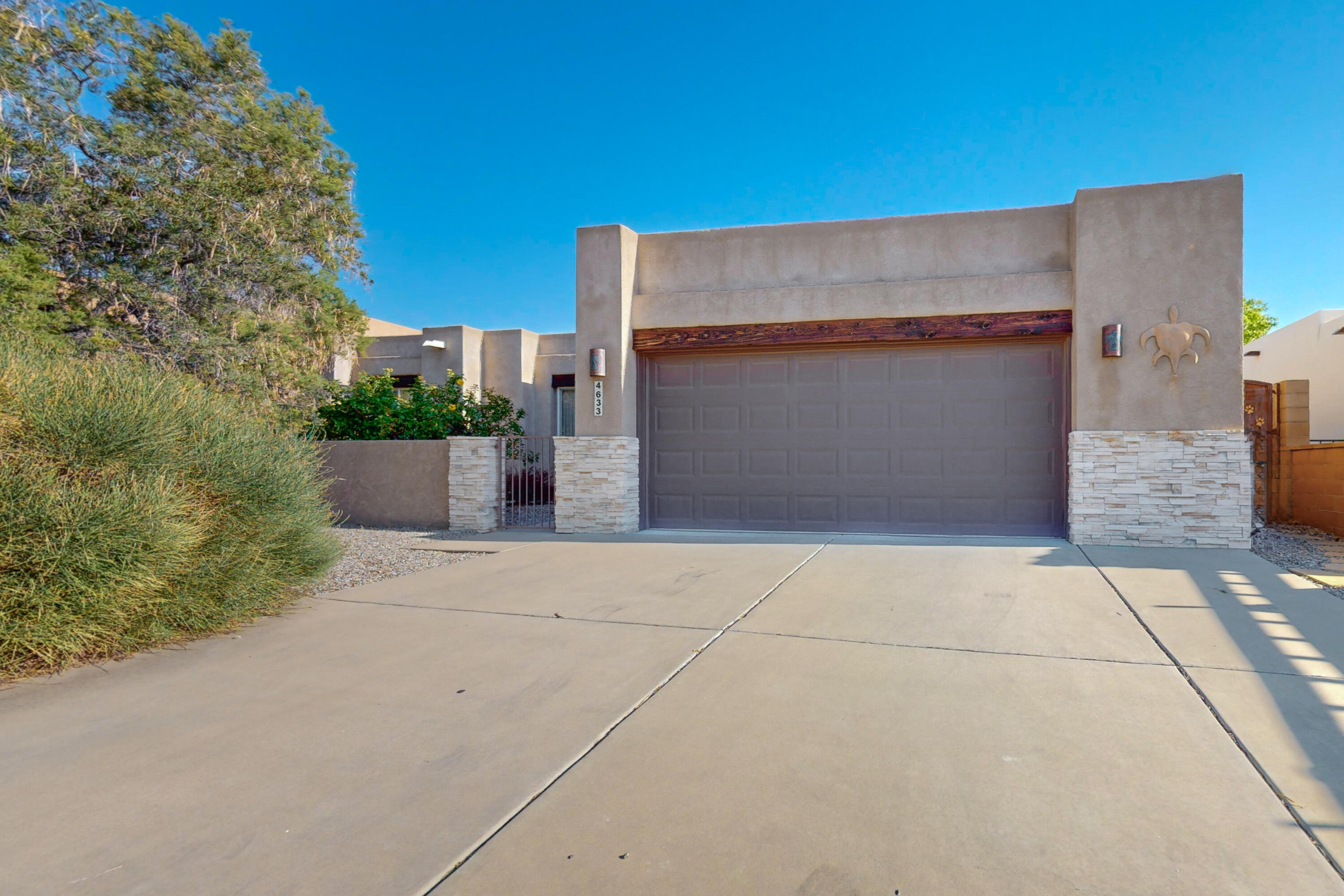 Discover this stunning single-story home, beautifully crafted in traditional pueblo style, offering a perfect blend of elegance and comfort. As you step inside, you'll be greeted by the charming kiva fireplace, a centerpiece that exudes warmth and invites you to relax and unwind. The elegant tile countertops in the kitchen and bathrooms add a touch of sophistication, while the exposed wood ceilings throughout the home bring a sense of rustic charm and character.The open floorplan is bathed in natural light, thanks to the strategically placed windows that allow the sun to pour in, creating a welcoming and airy atmosphere. This design not only enhances the aesthetic appeal but also makes the space feel larger and more inviting.