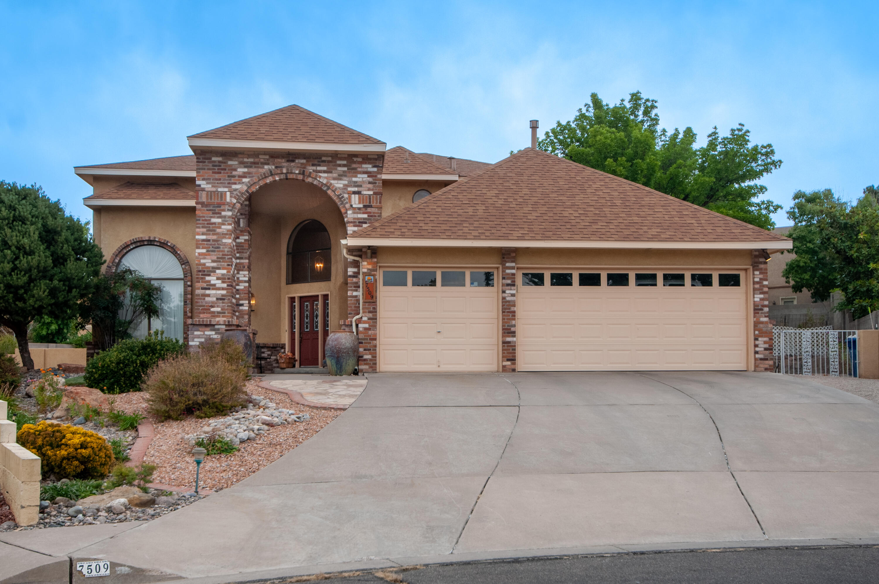 Meticulously maintained, south-facing home on a quiet cul-de-sac in Heritage East in the La Cueva HS district. Living and dining room have soaring ceilings.  Open eat-in kitchen has ample cabinets and drawers. Pantry cabinets with slide-out shelving.  Gas log brick fireplace is inviting for cozy evenings.  Primary is on the main level, 2 closets and full bath.  Half bath and laundry finish downstairs. Beautiful staircase leads upstairs to FOUR more bedrooms and 2 3/4 baths.  One is perfect for an office.   Home sits on a beautifully landscaped 1/3 acre including a lovely cascading waterfall. Huge patio, basketball court, garden, and backyard access.  3-car garage with long driveway.  So much storage including attic space over the entire space.   Welcome home!