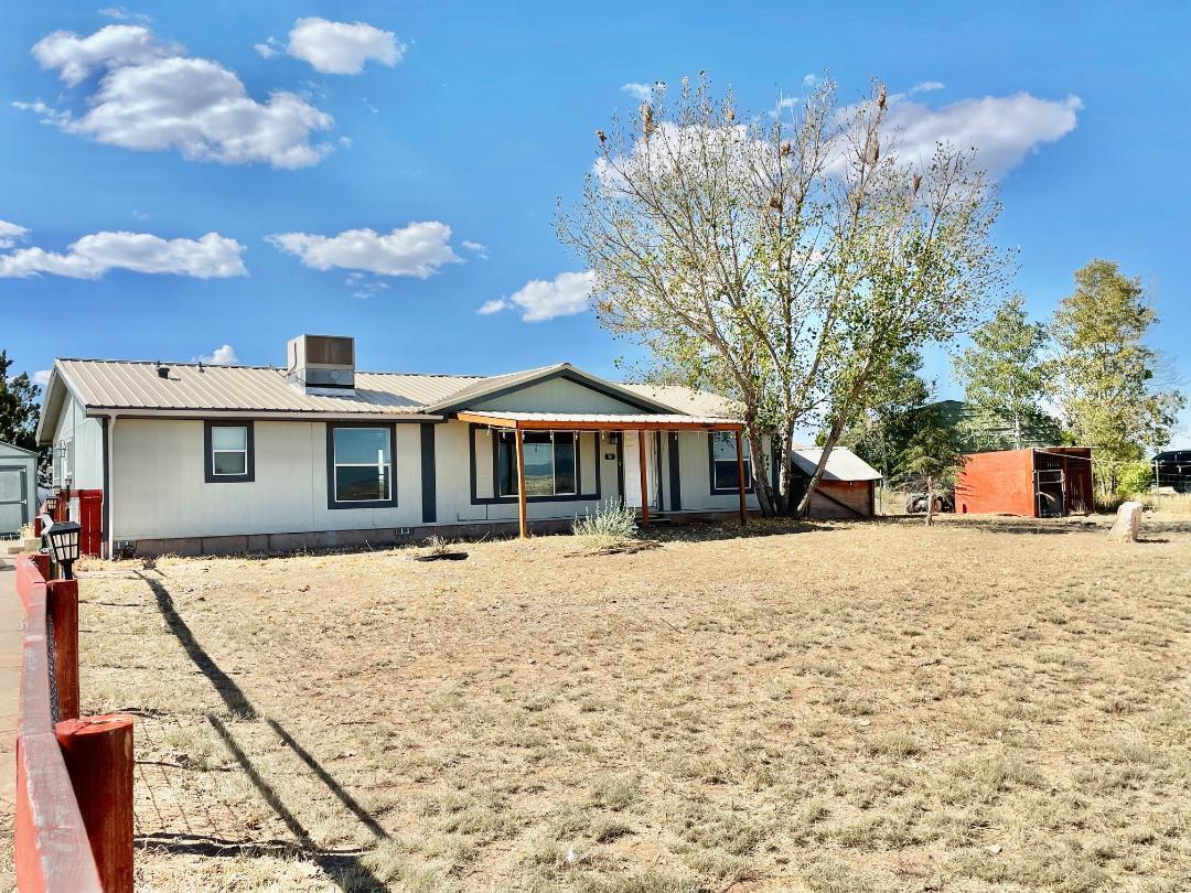 Situated in a prime location between Edgewood and Moriarty, just off Old 66 with paved roads, this double-wide features a metal roof and solar panels. The open floor plan includes a kitchen abundant with cabinets and an optimal layout. The den has potential to be transformed into a third bedroom. The front yard is fenced, perfect for pets, and comes with two large storage sheds. Community Water and Natural Gas. The property requires some TLC but not extensively. This home is part of an estate and is being sold 'as is'.