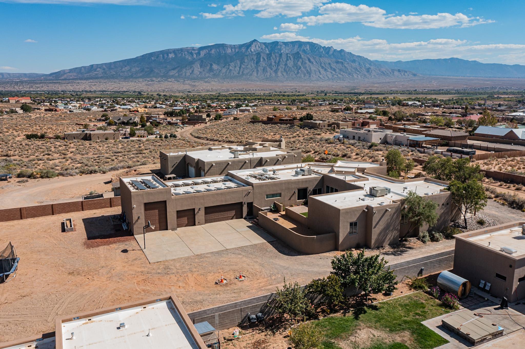 This stunning 4,388 square foot residence boasts 3 spacious bedrooms, a large study and a dedicated enormous media room, perfect for entertaining or relaxing with family. The expansive layout provides ample room for gatherings and everyday living. Enjoy breathtaking views of the Sandia Mountains from multiple vantage points throughout the home. The large windows flood the space with natural light, creating a warm and inviting atmosphere. The property also features a remarkable multi-car garage, with one bay designed specifically for RV garage--ideal for adventure enthusiasts. Plus, the paid/owned solar panels ensure energy efficiency, keeping your utility costs low while contributing to a sustainable lifestyle. This home combines luxury, comfort, and