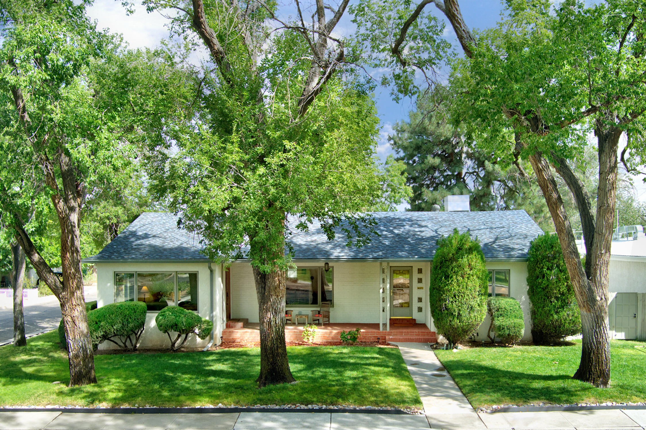 This classic UNM home was believed to be built by McDuffie for his family, & was architect reimagined in '06 preserving the original character. It overlooks Bataan Park with lush grass & old growth trees. The eat-in kitchen opens to one of the three living spaces. It has Richlite solid surface counters, Subzero refrigerator, Decor gas range, KitchenAid oven & microwave, & a Bosch dishwasher. The primary bedroom has 3 closets. Walk out basement can be used as a sperate apartment with its own entry, living, bedroom, bath & kitchenette. Private backyard with lots of shade, & a built in fireplace. Oversized 2 car garage with workshop space. Refrigerated a/c with a whole house humidifier & two evaporative units for cooling options. Only blocks from UNM Hospital, Campus & Nob Hill.