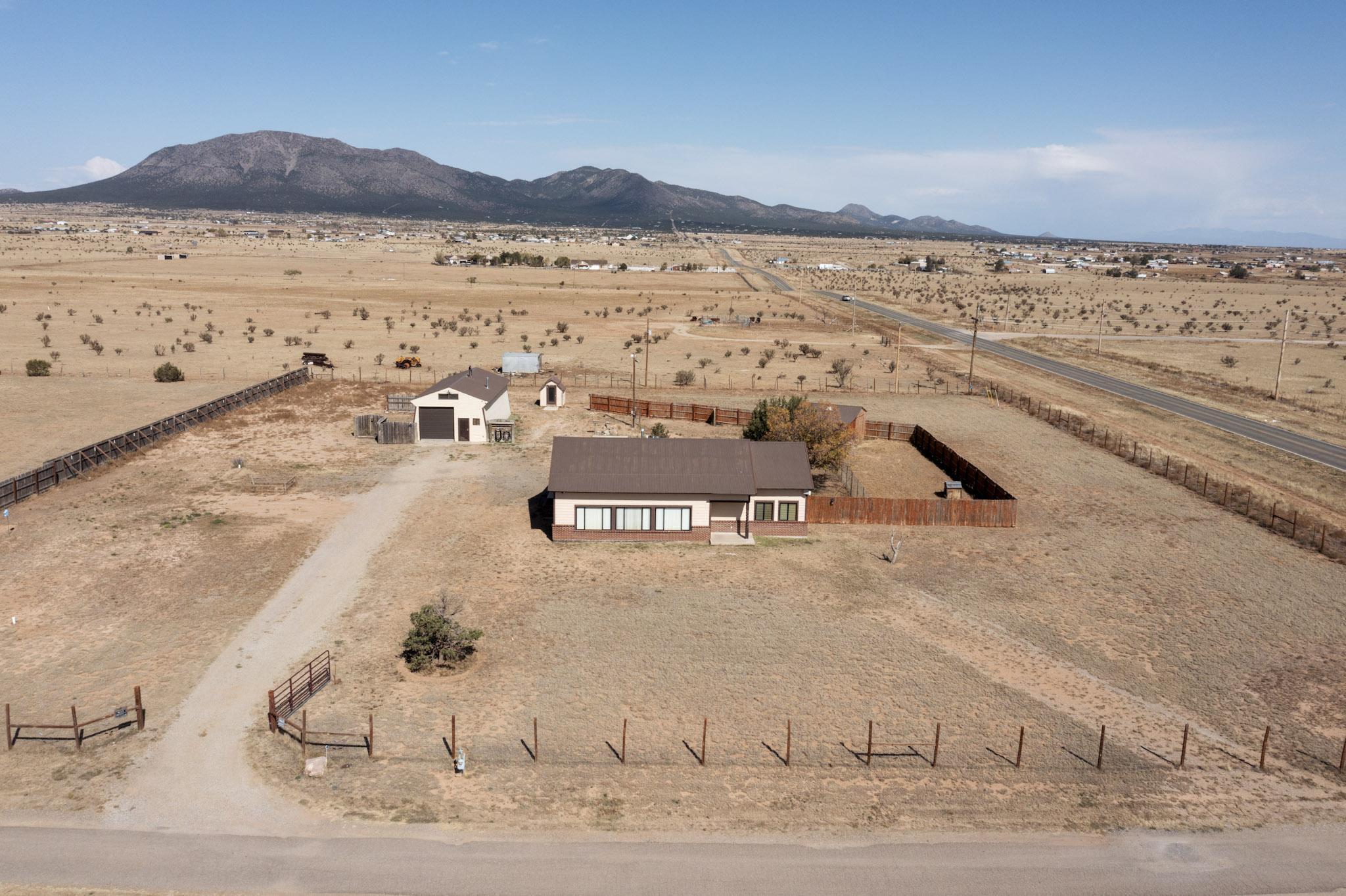 Impeccably maintained custom home in the heart of Edgewood, NM! This split-level home has had many incredible updates in recent years, including a full kitchen remodel, bathrooms, flooring, paint, you name it! The pellet stove is on a thermostat and provides warmth throughout the entire home. High ceilings in the living room and tons of natural light create a warm and inviting space. Sitting on over 2 acres with beautiful views of South Mountain, there are multiple outbuildings, including a chicken coop, a shed with electricity, and an incredible nearly 1000-square-foot workshop with 300 feet of loft space, complete with multiple heat sources.