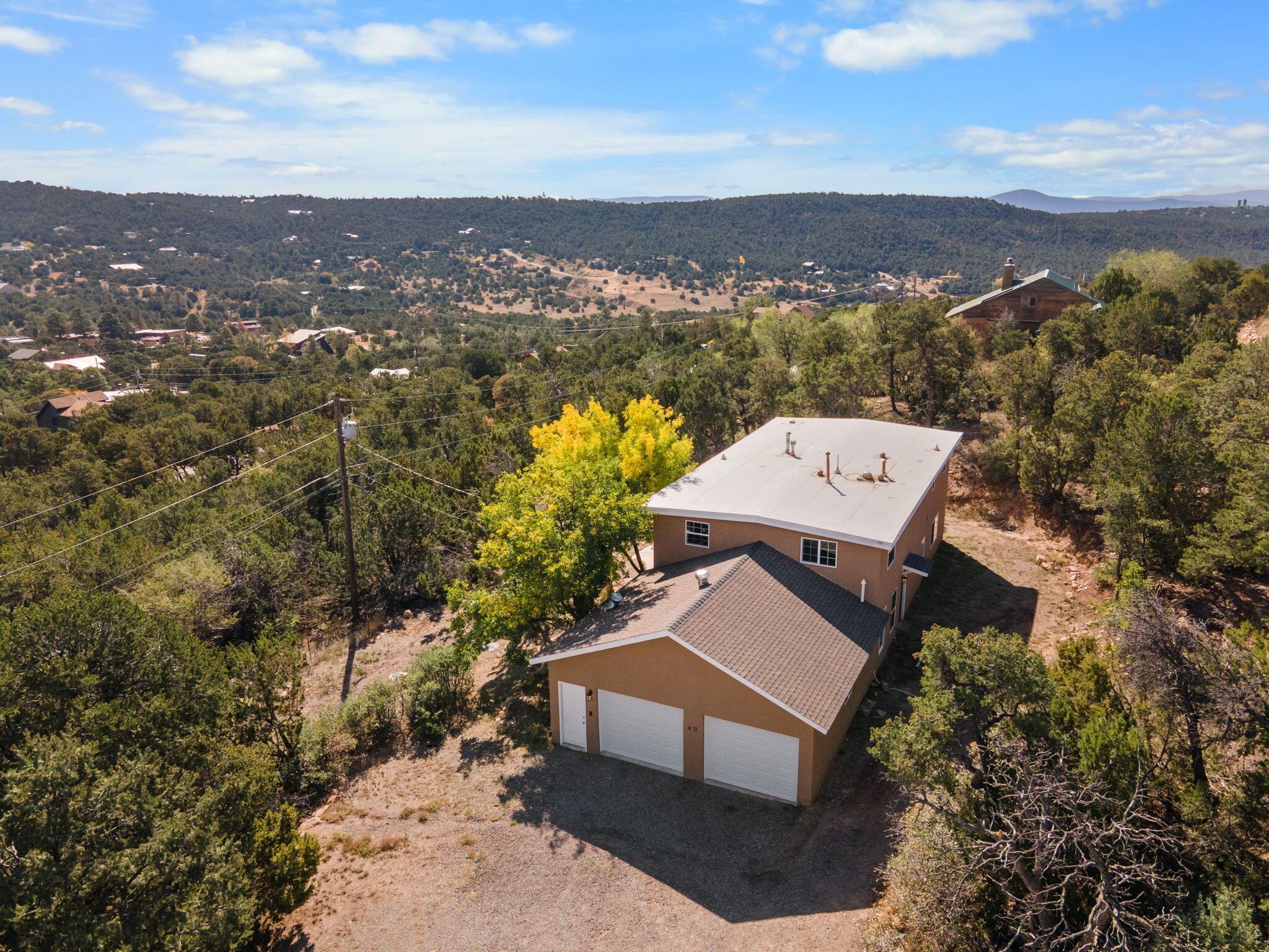 $10,000 of credits offered by sellers! Escape the hustle and bustle of city life and enjoy the serenity of mountain living. This beautiful home is nestled in the picturesque mountains of Cedar Crest, offering a peaceful retreat while still being just a 20-minute drive from Albuquerque! Enjoy the best of both worlds - the tranquility of nature with the convenience of a short commute to the city. Set on a spacious lot surrounded by stunning pine trees and fresh mountain air, this home provides privacy and breathtaking views of the Sandia Mountains. With 3 bedrooms, 2 bathrooms, and an open-concept living space, it's perfect for those seeking a lifestyle of comfort and tranquility. The large windows flood the home with natural light and showcase the beauty of the surrounding landscape.